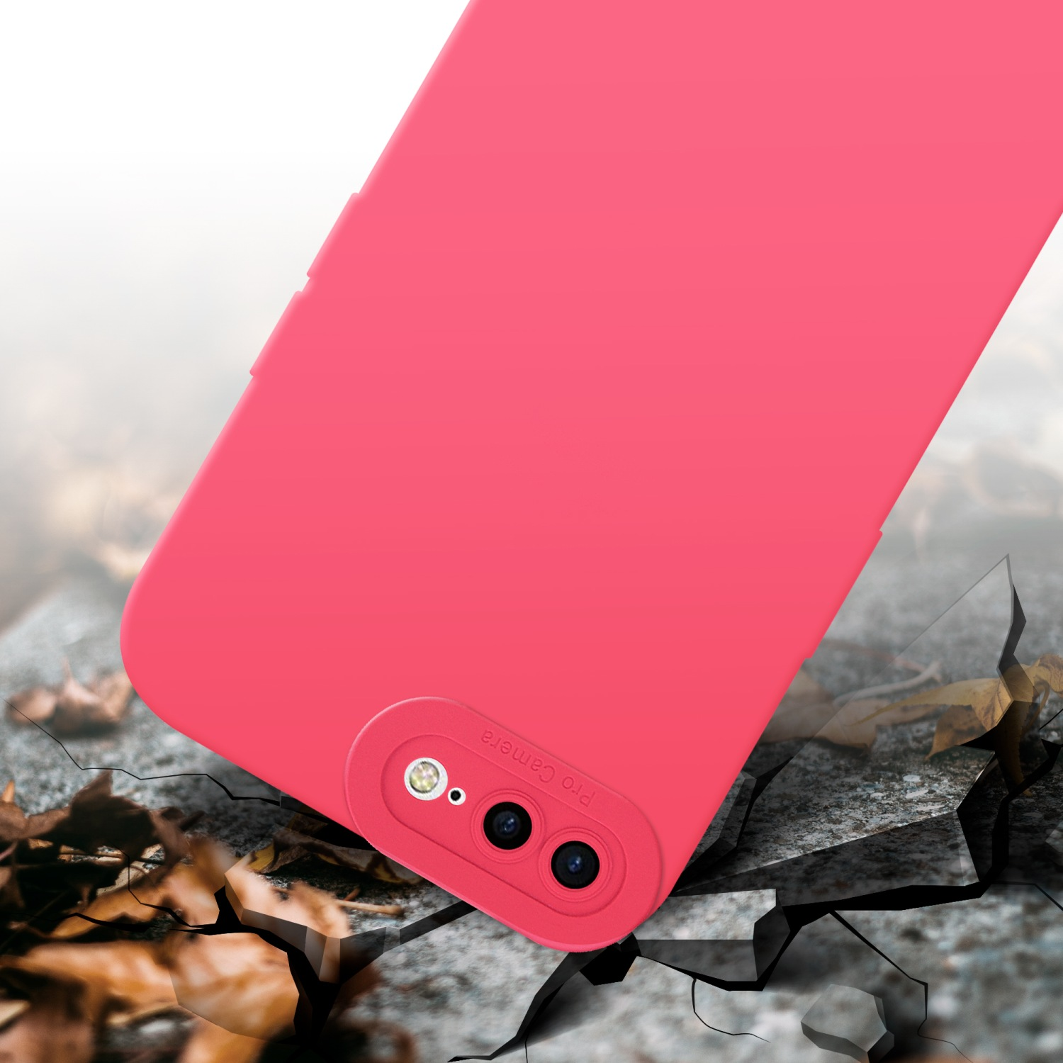 Custodia rosa per telefono che cade su terreno crepato con foglie.