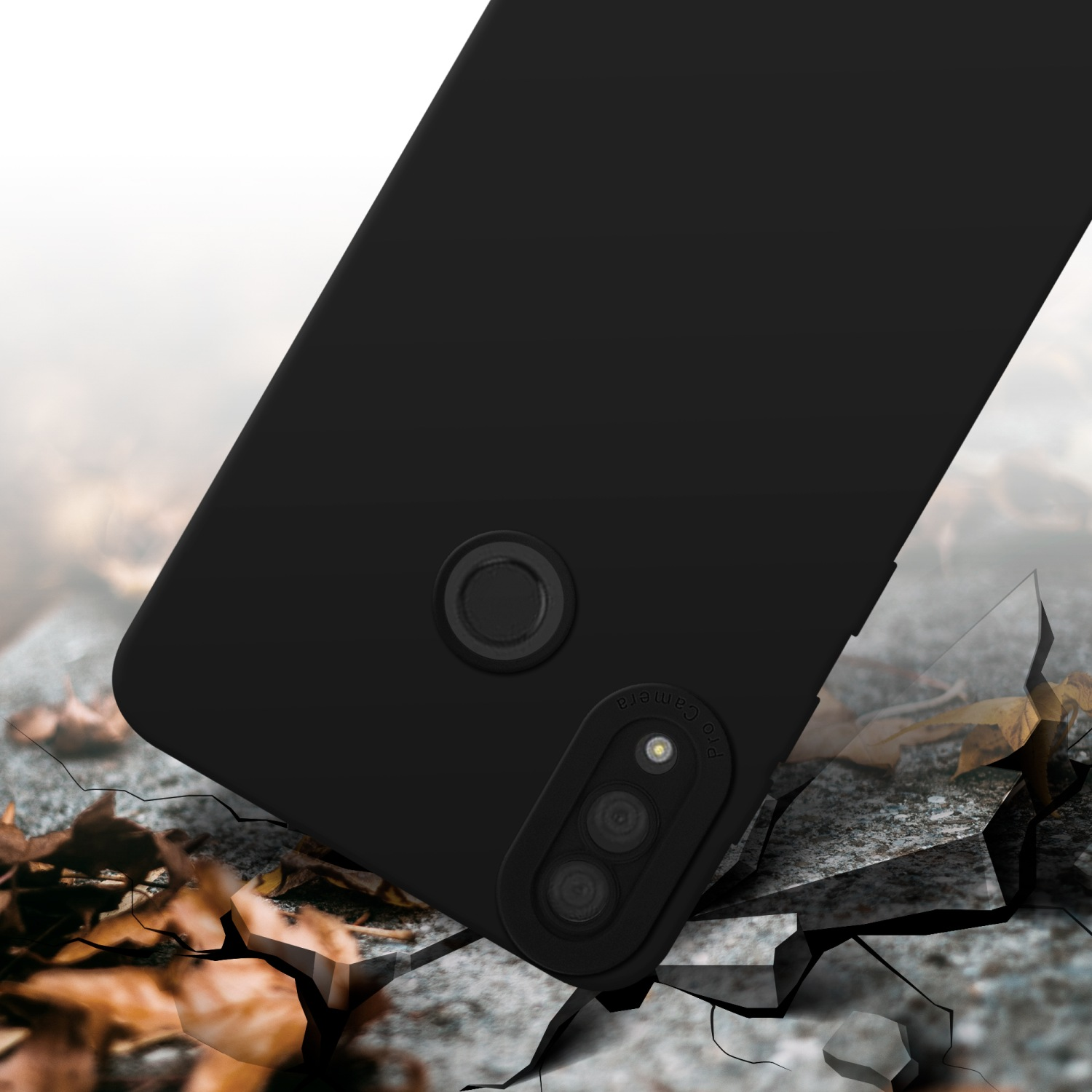 Coque de téléphone noire sur une surface fissurée. Module caméra visible. Feuilles en arrière-plan.