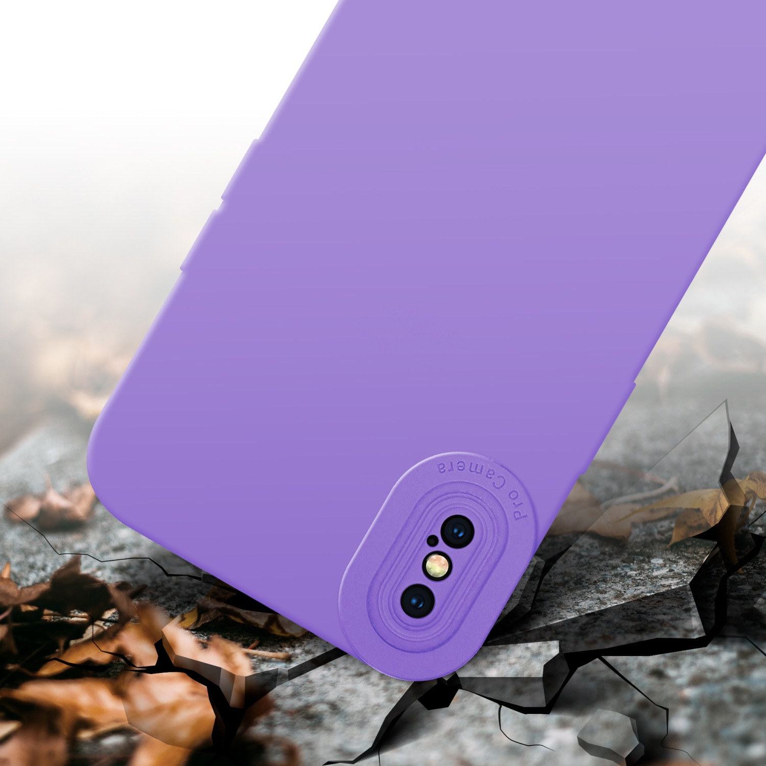 Una custodia per telefono viola con un rialzo per la fotocamera è su una superficie incrinata con foglie.