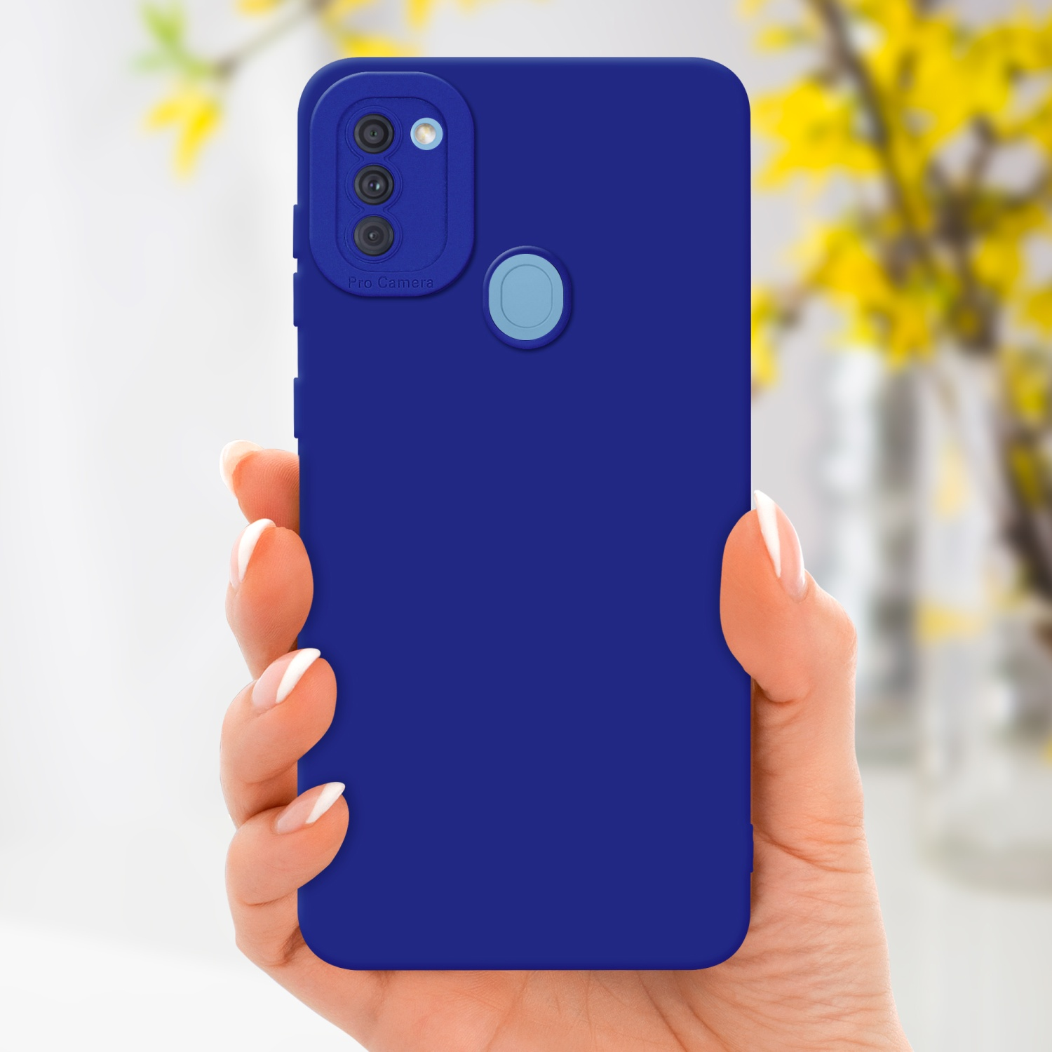 Una mano tiene una custodia blu per telefono con una sezione fotocamera. Fiori gialli sullo sfondo.