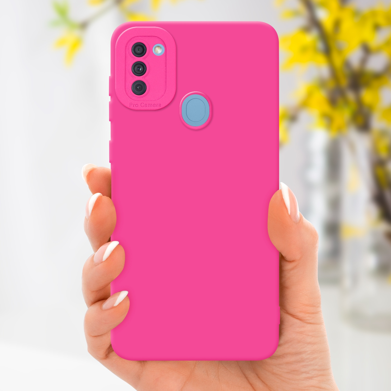 Una mano che tiene una custodia rosa con fotocamera Pro. Fiori gialli sullo sfondo.