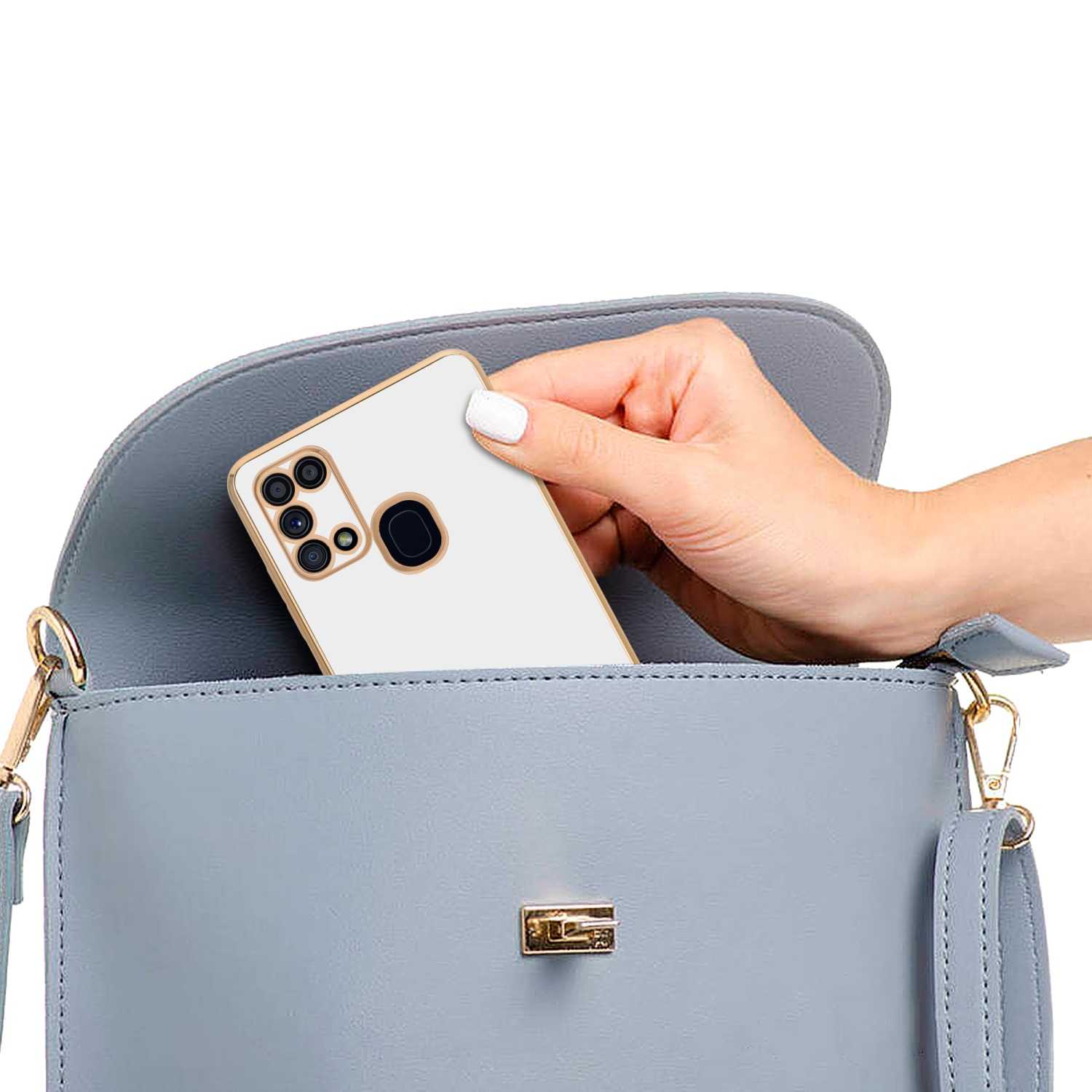 Hand hält Telefon in hellblauer Handtasche. Telefon in weißer Hülle mit goldenem Rand.