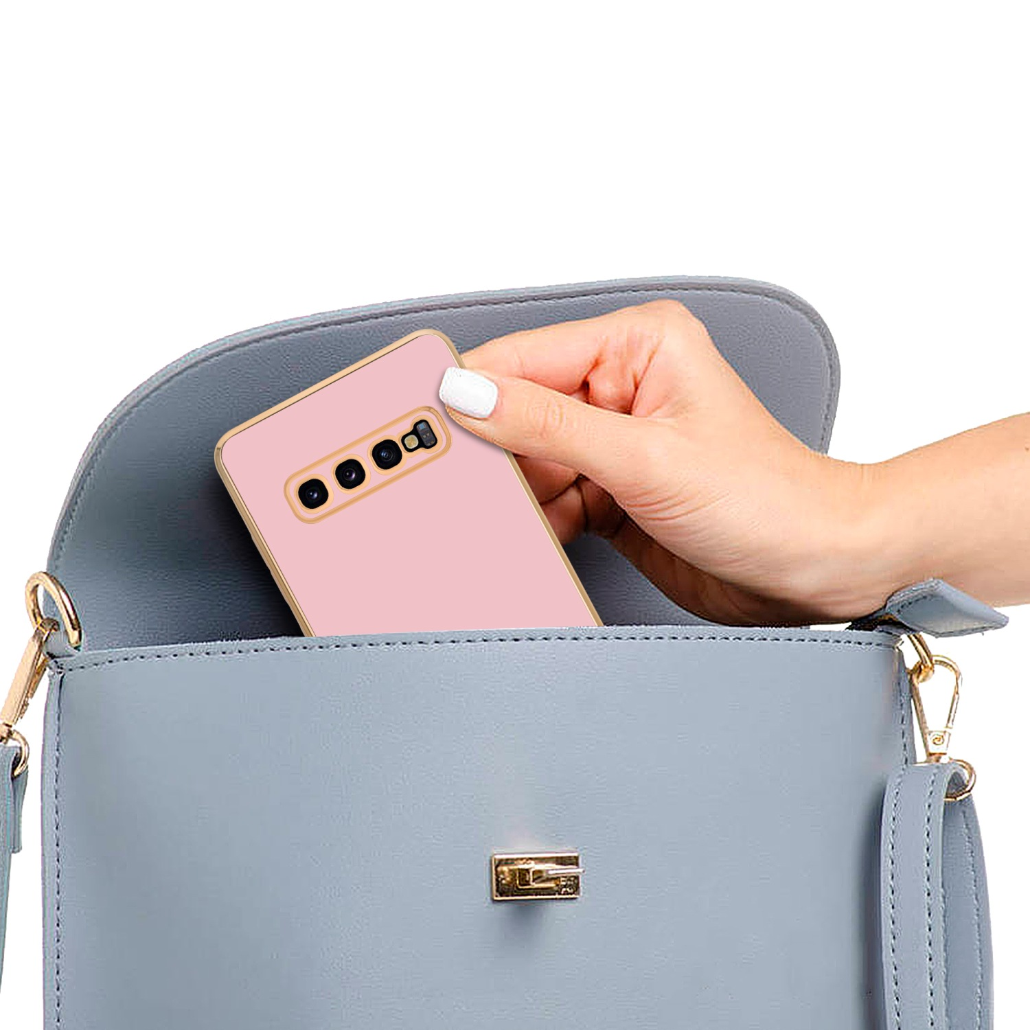 Rosa Handyhülle in einer blauen Handtasche. Hand hält ein rosa Telefon. Weißer Nagellack.