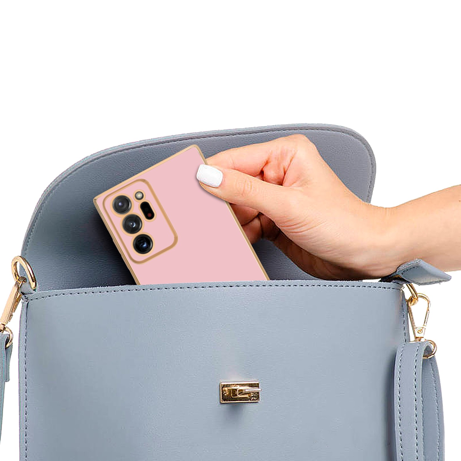 Ein pinkes Telefon in einer grauen Handtasche, eine Hand hält das Telefon.