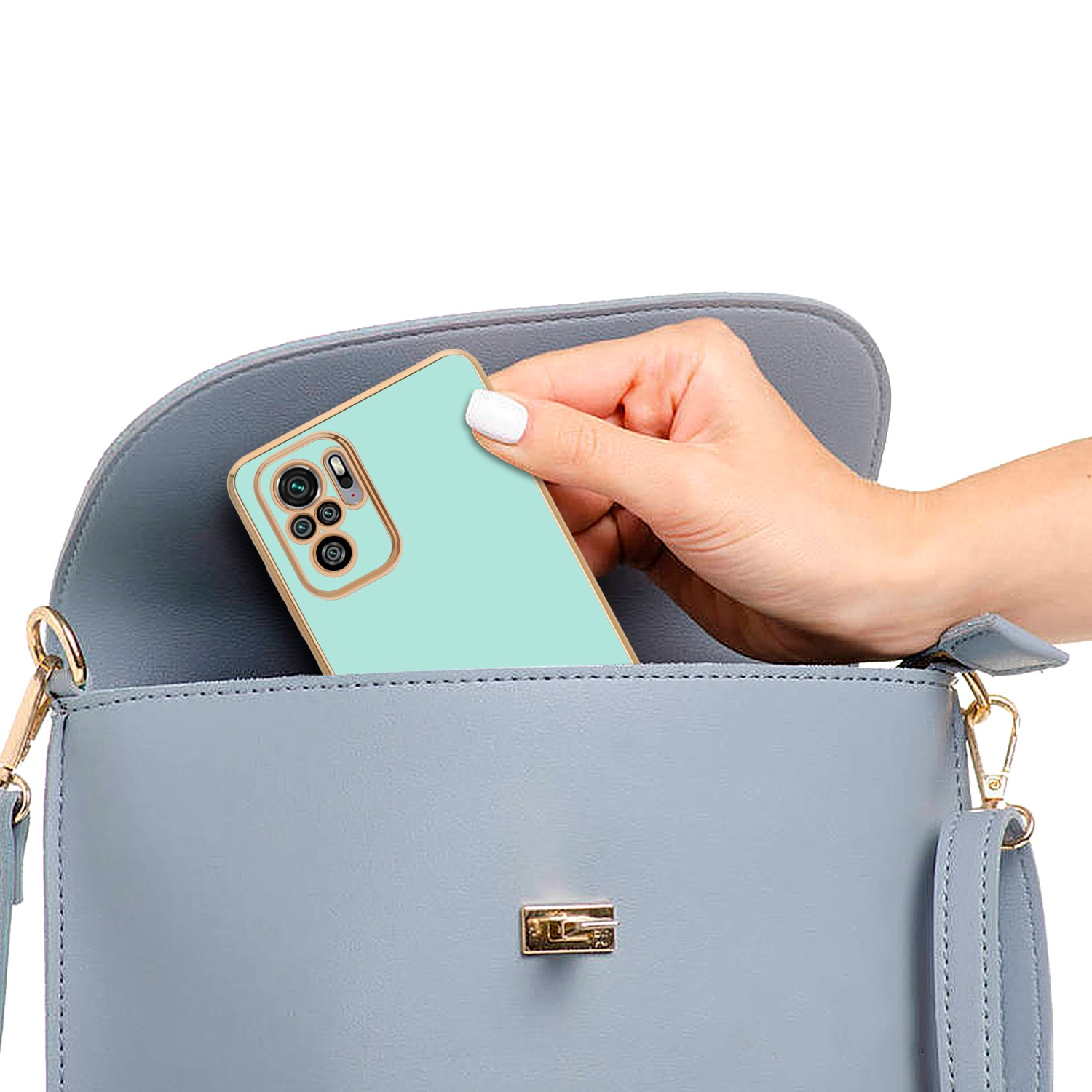 Persona che mette il telefono in una borsa grigia. Il telefono è in una custodia verde menta.