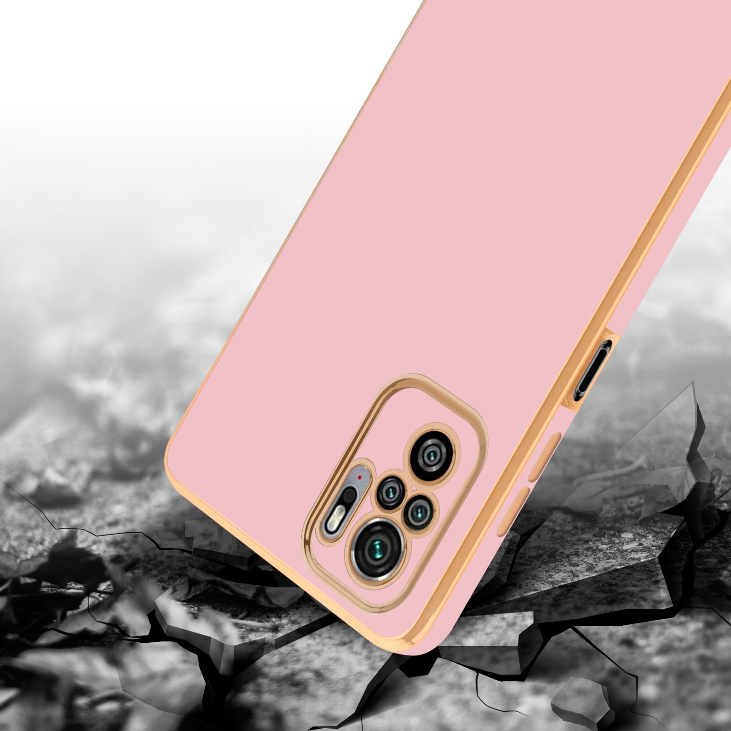 Custodia per telefono rosa con bordi dorati su un terreno crepato e uno sfondo luminoso.