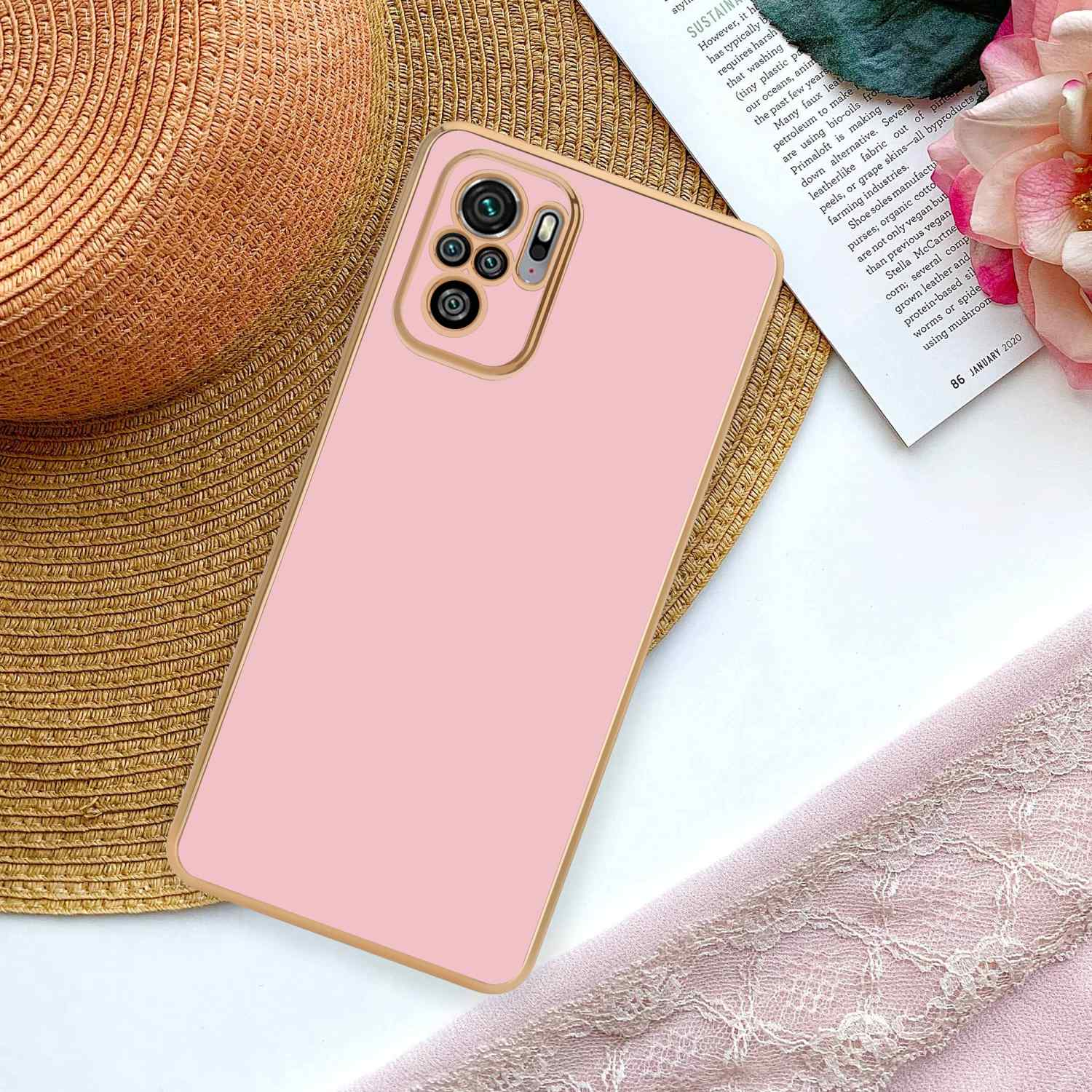 Una custodia per telefono rosa su uno sfondo con un cappello e una rivista.
