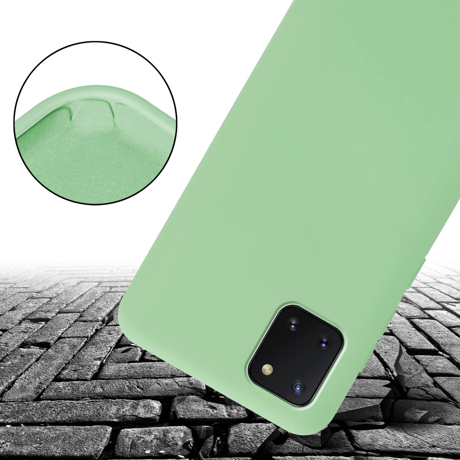 Eine grüne Handyhülle auf einem Ziegelgrund. Das Telefon hat eine Kamera.