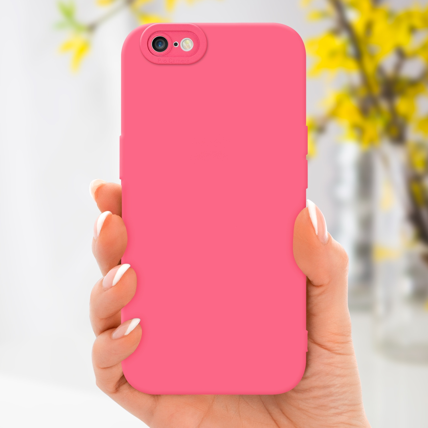 Mano che tiene una custodia rosa per telefono. Fiori gialli sullo sfondo, unghie bianche.