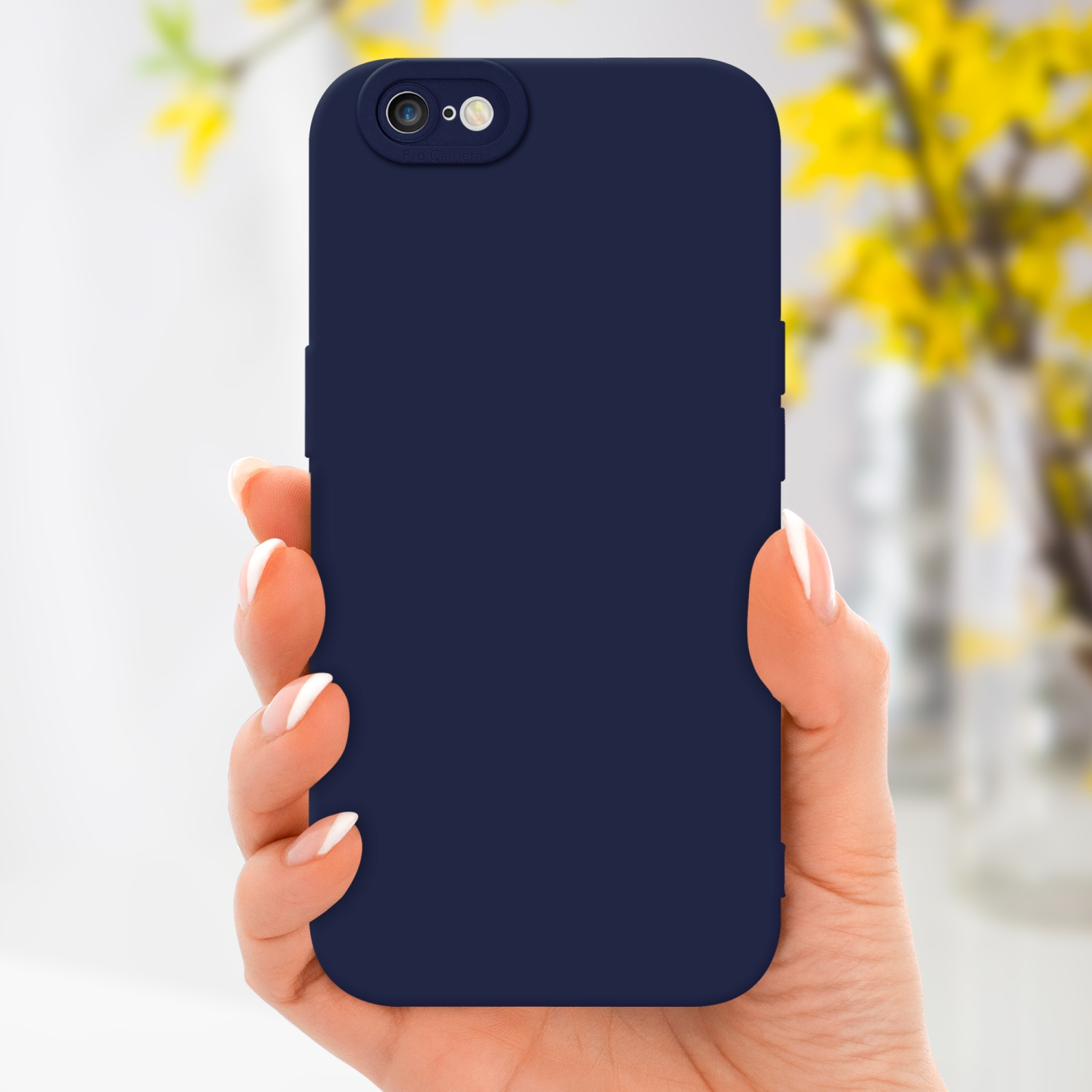 Mano che tiene una custodia blu navy con fotocamera pro, con fiori gialli sullo sfondo.