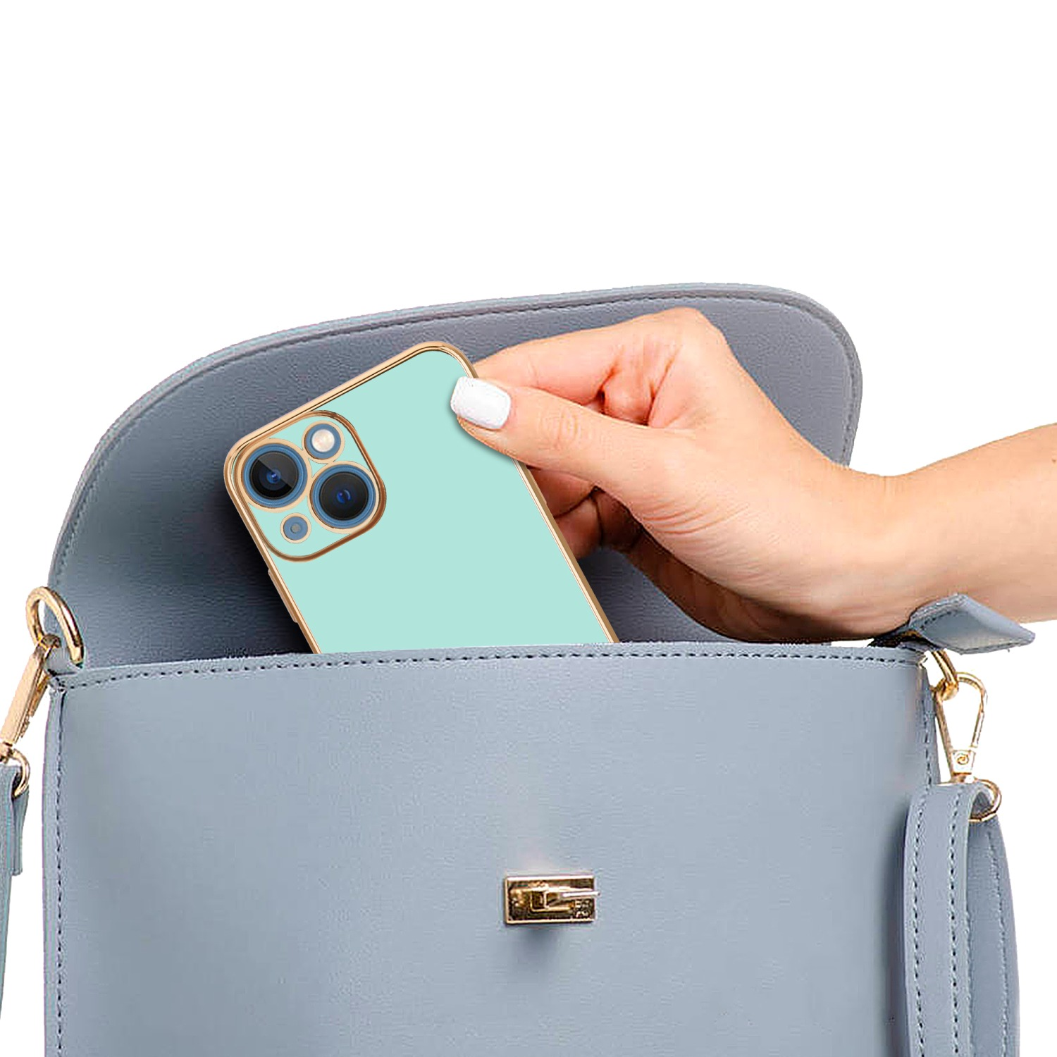 Eine Hand, die eine Handyhülle in eine blaue Handtasche legt.