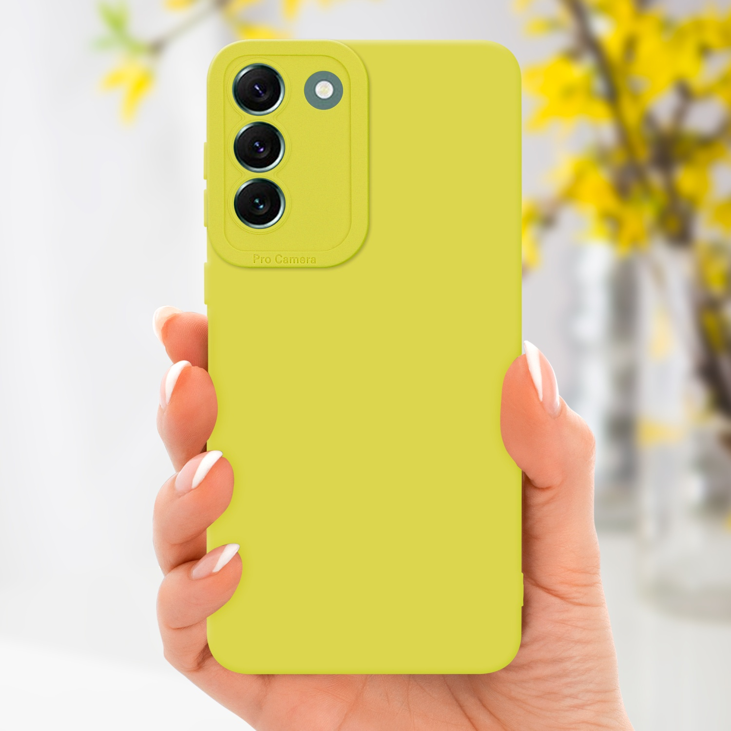 Una mano che tiene una custodia gialla con tre obiettivi della fotocamera.