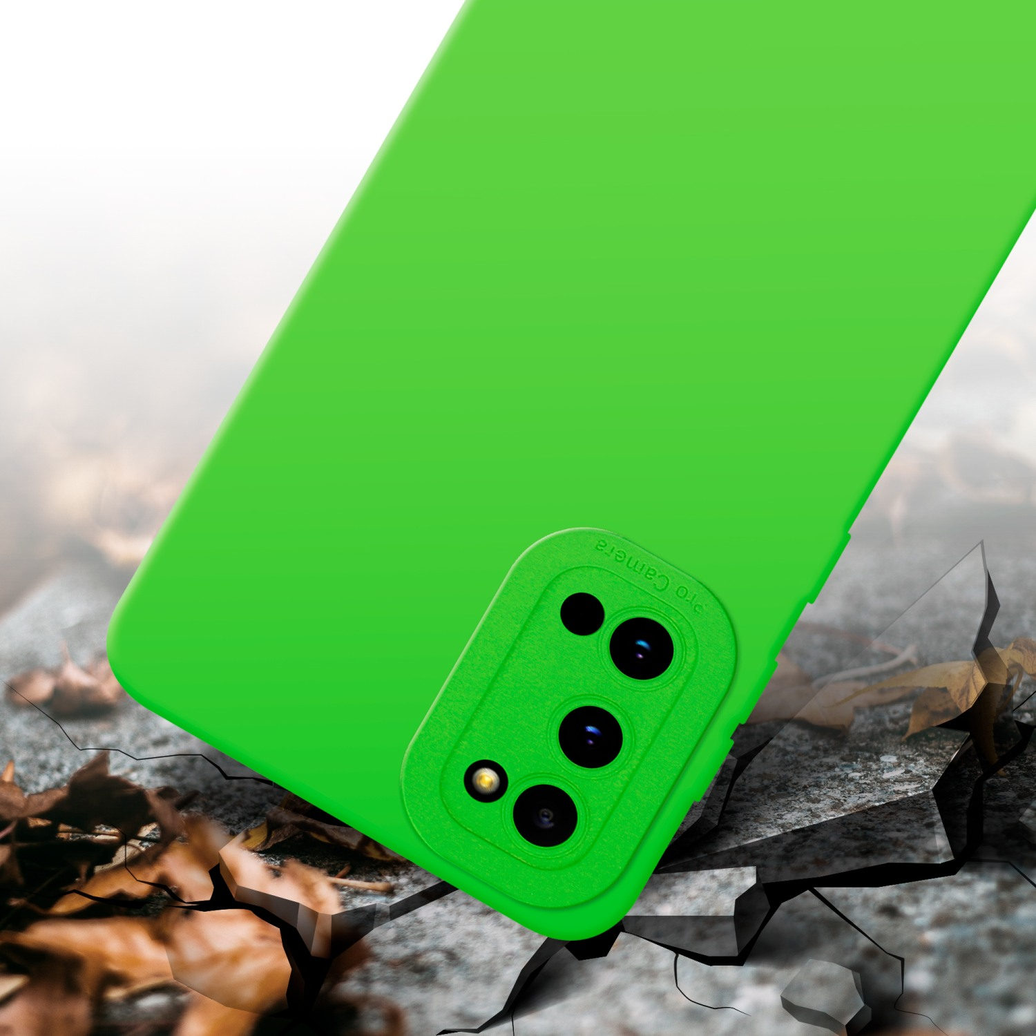 Coque de téléphone verte sur surface craquelée. Module caméra vert visible. Débris et fissures présents.