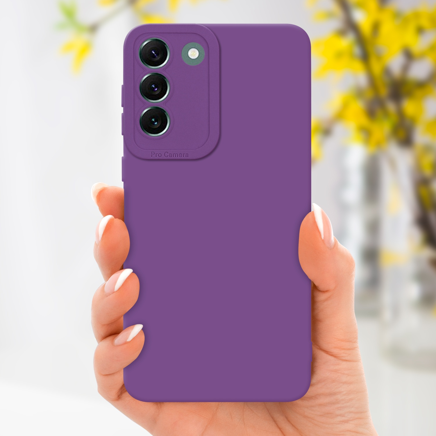 Mano che tiene una custodia viola con rialzo fotocamera, fiori gialli sullo sfondo.
