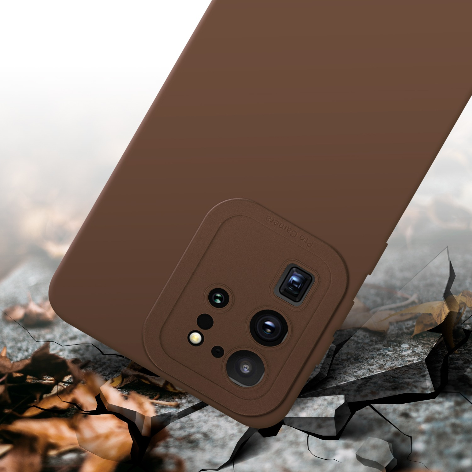 Una custodia marrone per telefono con un rialzo per la fotocamera è su una superficie screpolata. Foglie d'autunno sparse.