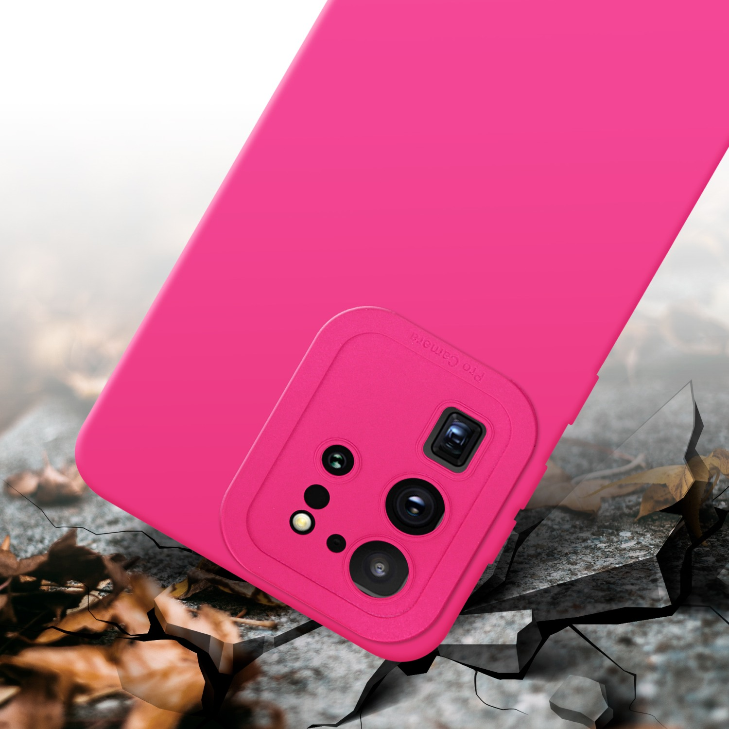 Custodia e fotocamera rosa su una superficie. Foglie e superficie in basso.