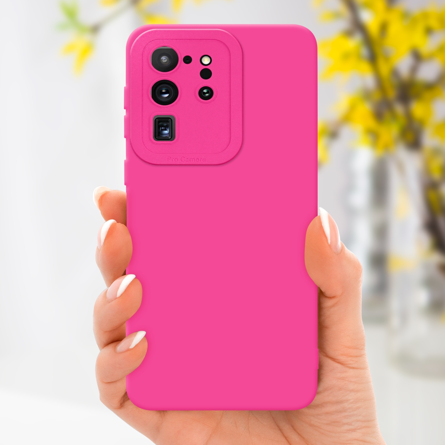 Una mano che tiene un telefono rosa in una custodia rosa. Fiori gialli sullo sfondo.