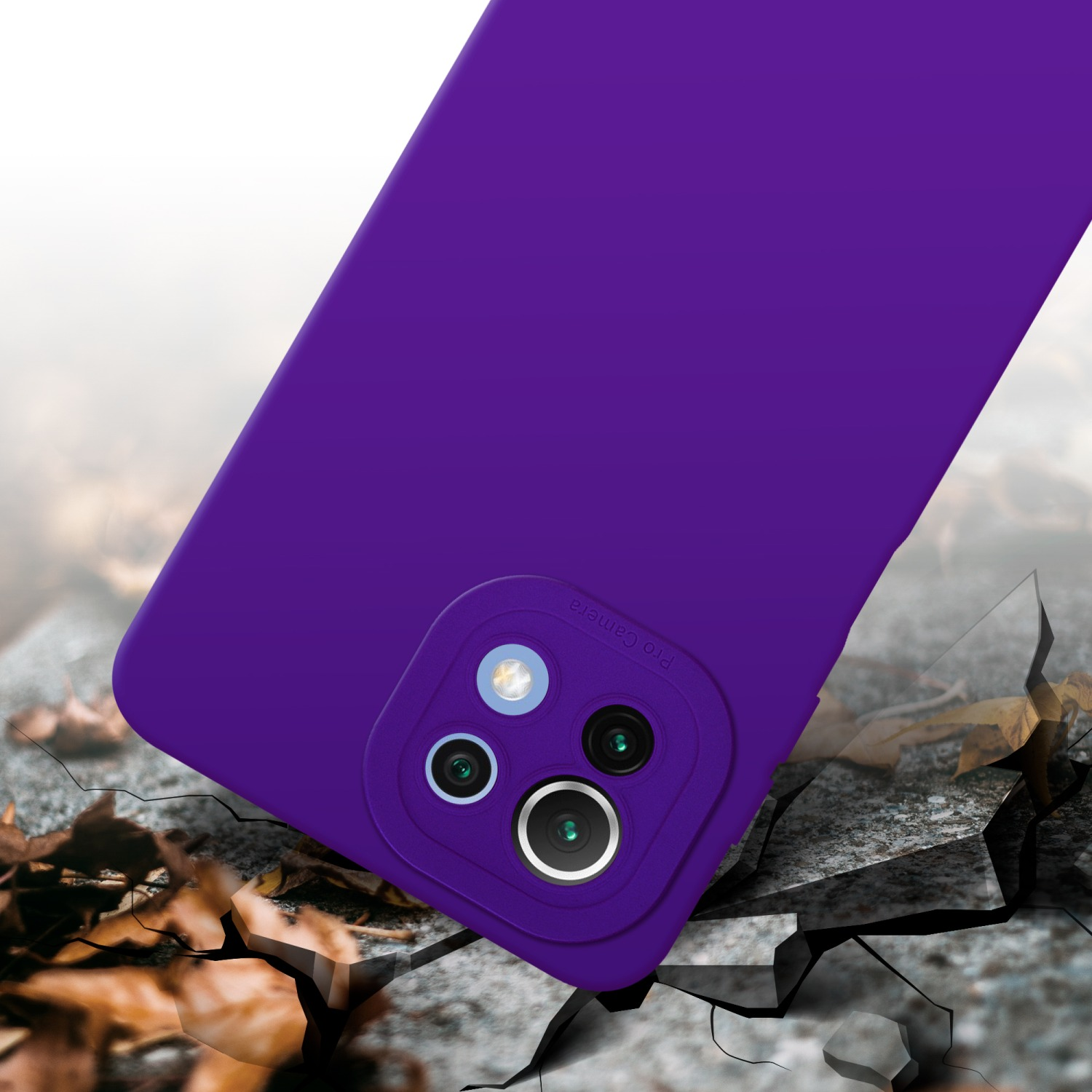 Custodia viola per telefono su superficie incrinata. Modulo fotocamera visibile. Foglie sullo sfondo.