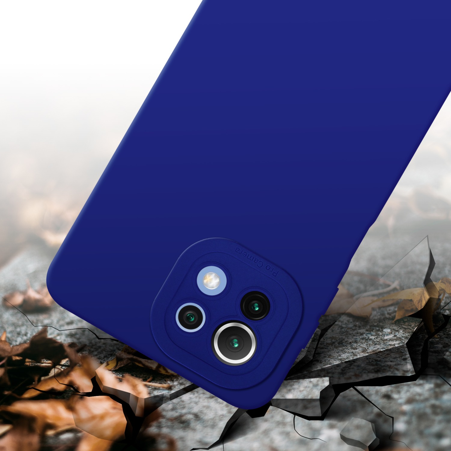 Une coque de téléphone bleue avec une caméra et une lentille sur une surface en béton fissurée. Feuilles en arrière-plan.