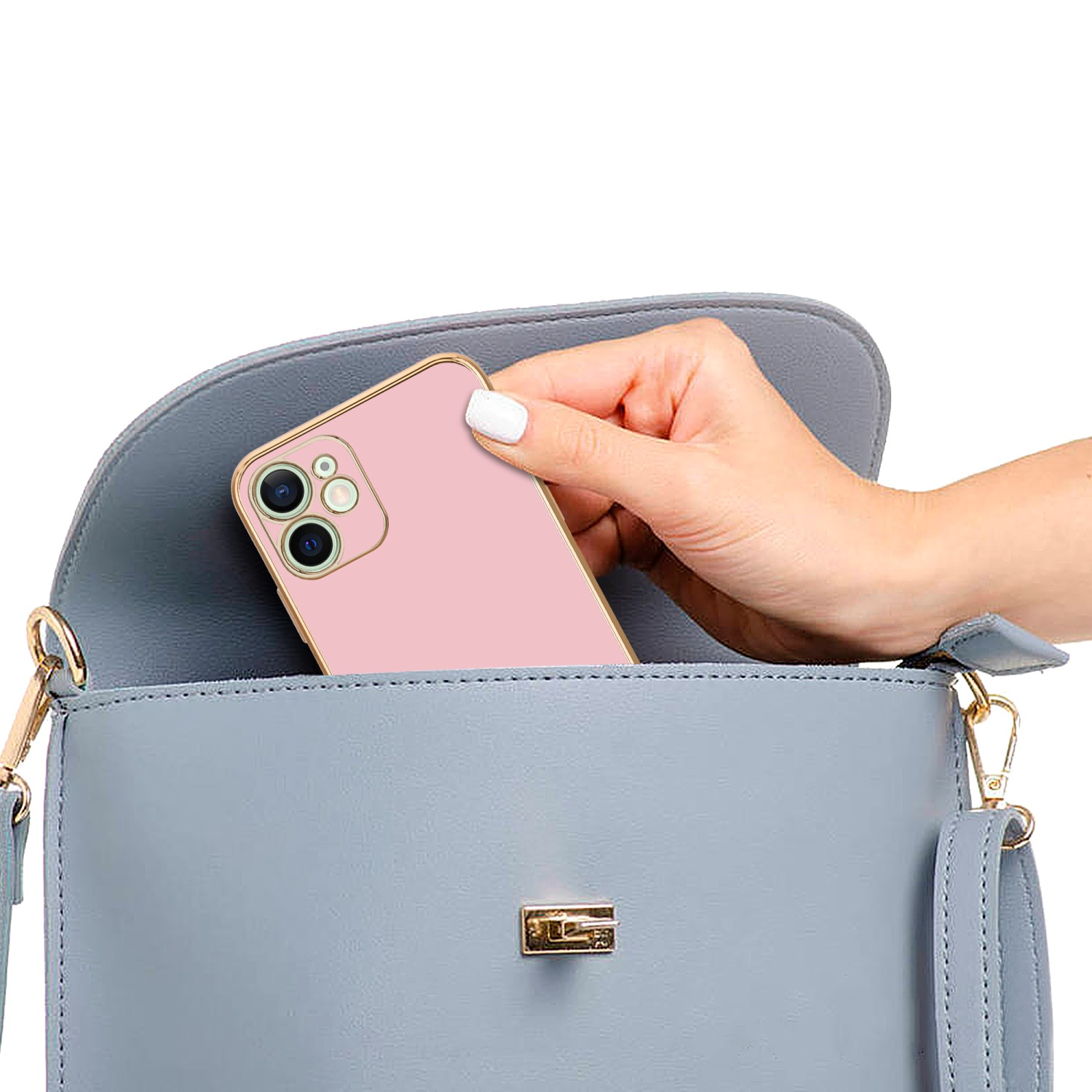 Hand hält ein pinkfarbenes Telefon in einer blauen Handtasche. Goldkanten der Hülle.