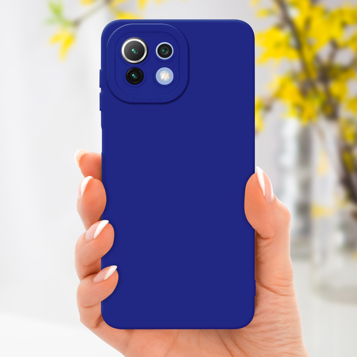 Main tenant un téléphone bleu. Des fleurs jaunes sont visibles en arrière-plan.