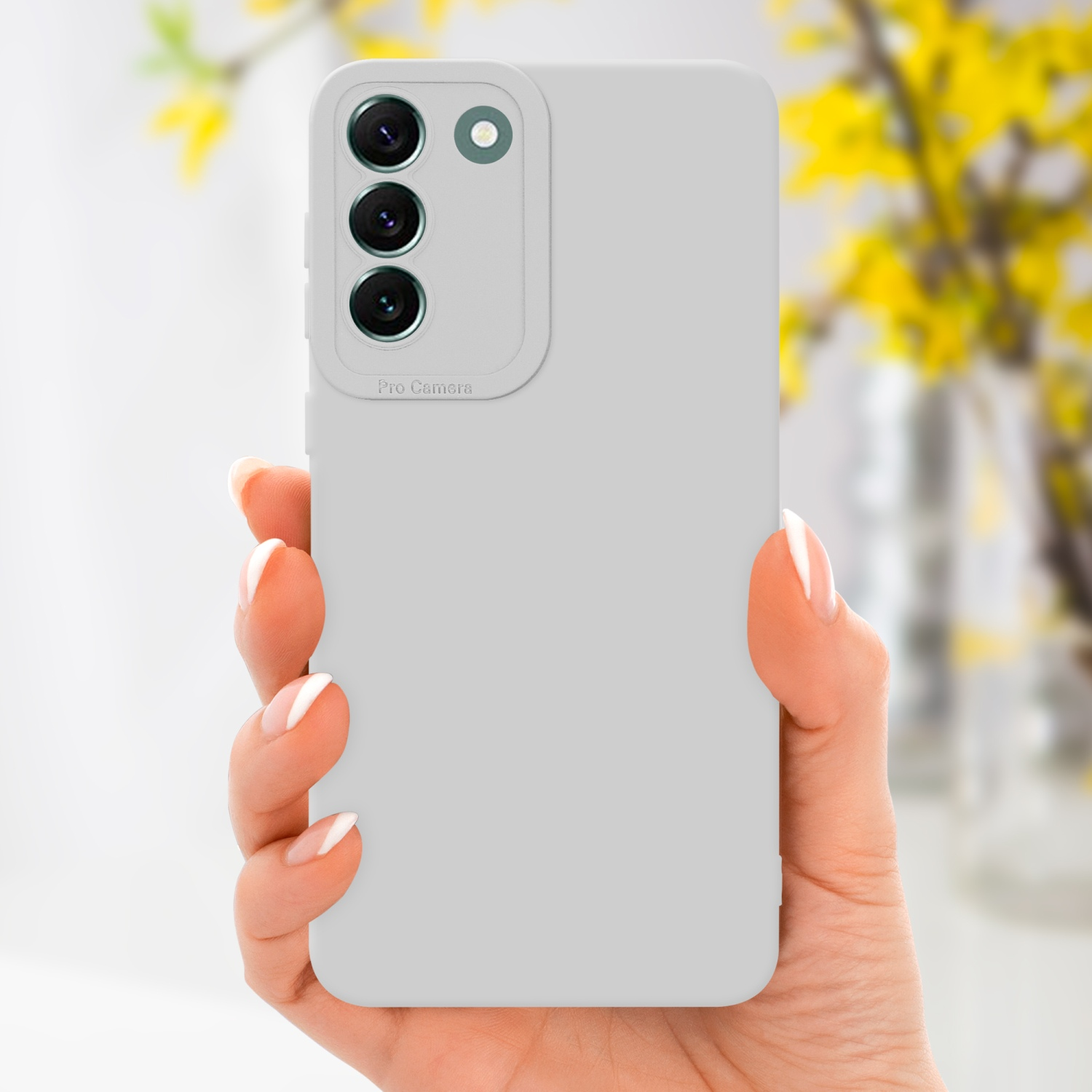 Una mano che tiene un telefono grigio chiaro con lenti della fotocamera.