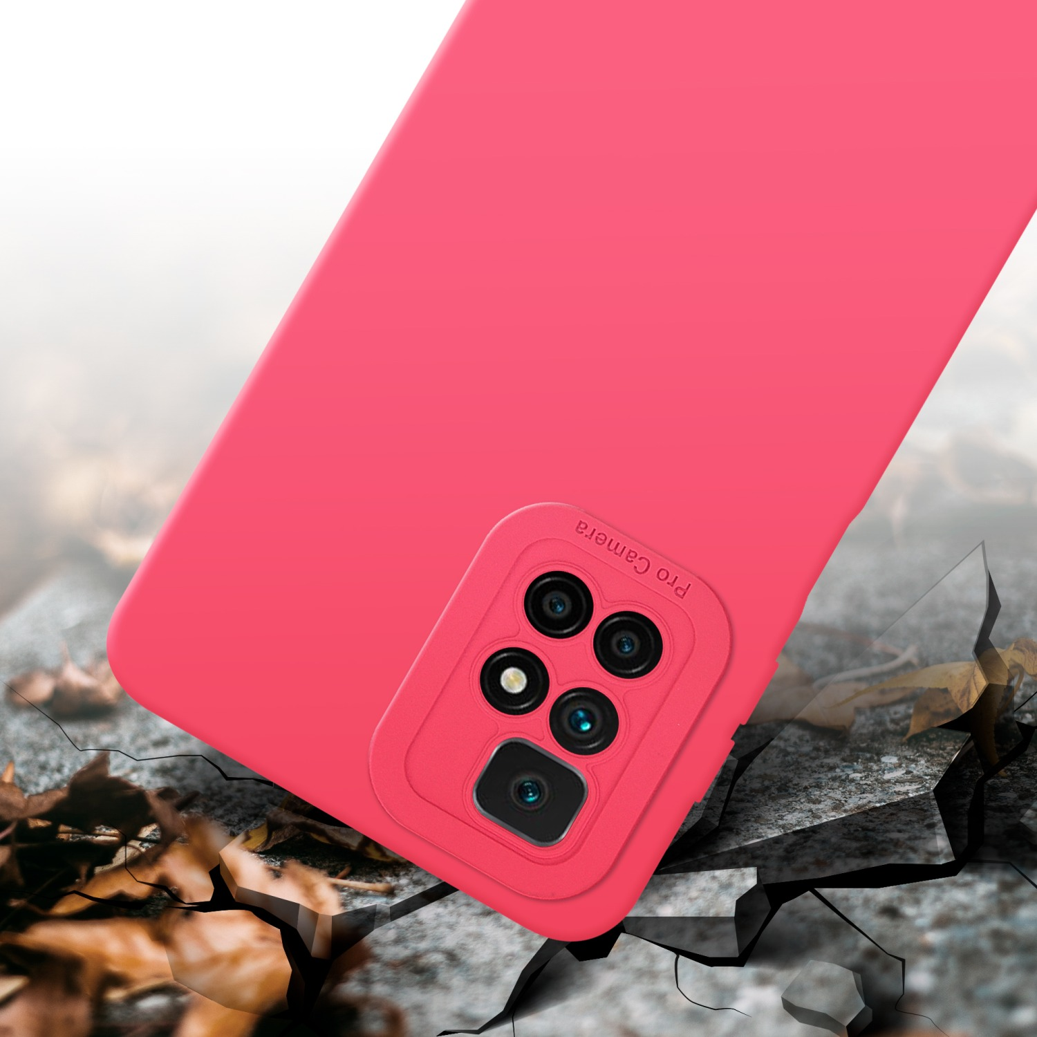 Coque de téléphone rose avec détail du module caméra. La coque est sur une surface fissurée. Lentilles de la caméra visibles.