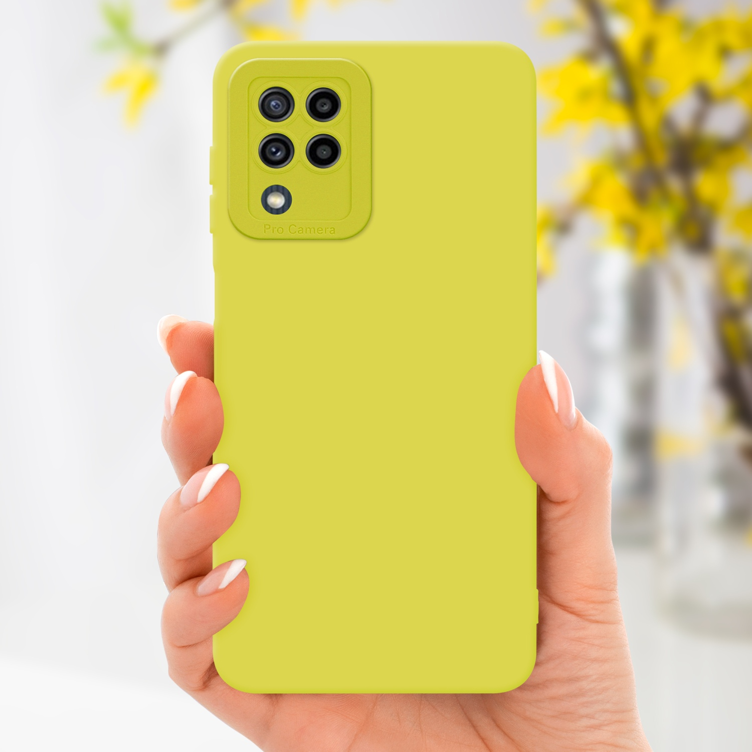 Mano che tiene un telefono giallo in una custodia gialla. Fiori gialli sfocati sullo sfondo.