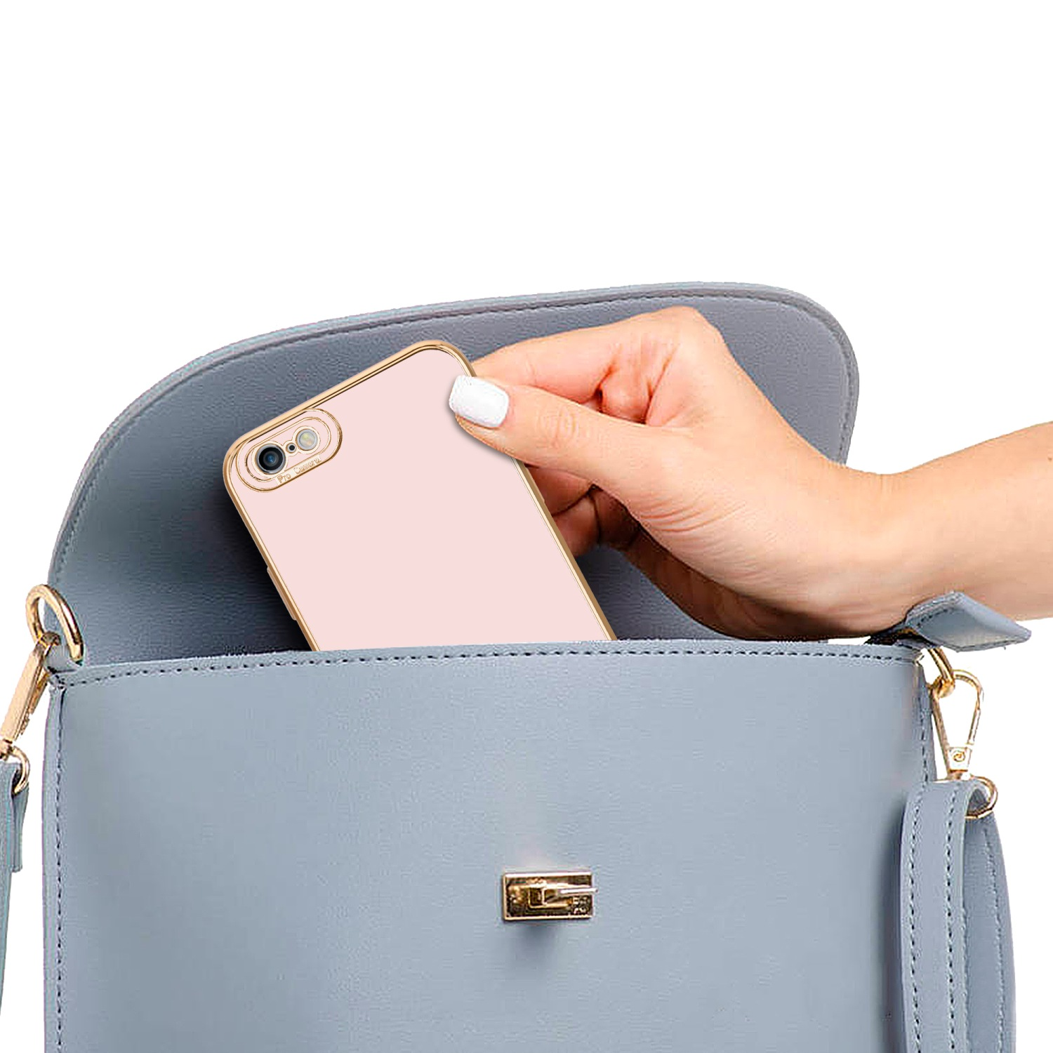 Hand legt eine rosa Handyhülle in eine blaue Handtasche.