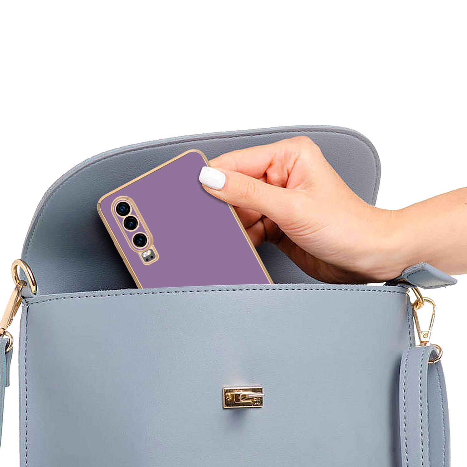 Eine Hand legt ein lila Telefon in eine hellblaue Handtasche. Die Tasche hat einen goldenen Verschluss.