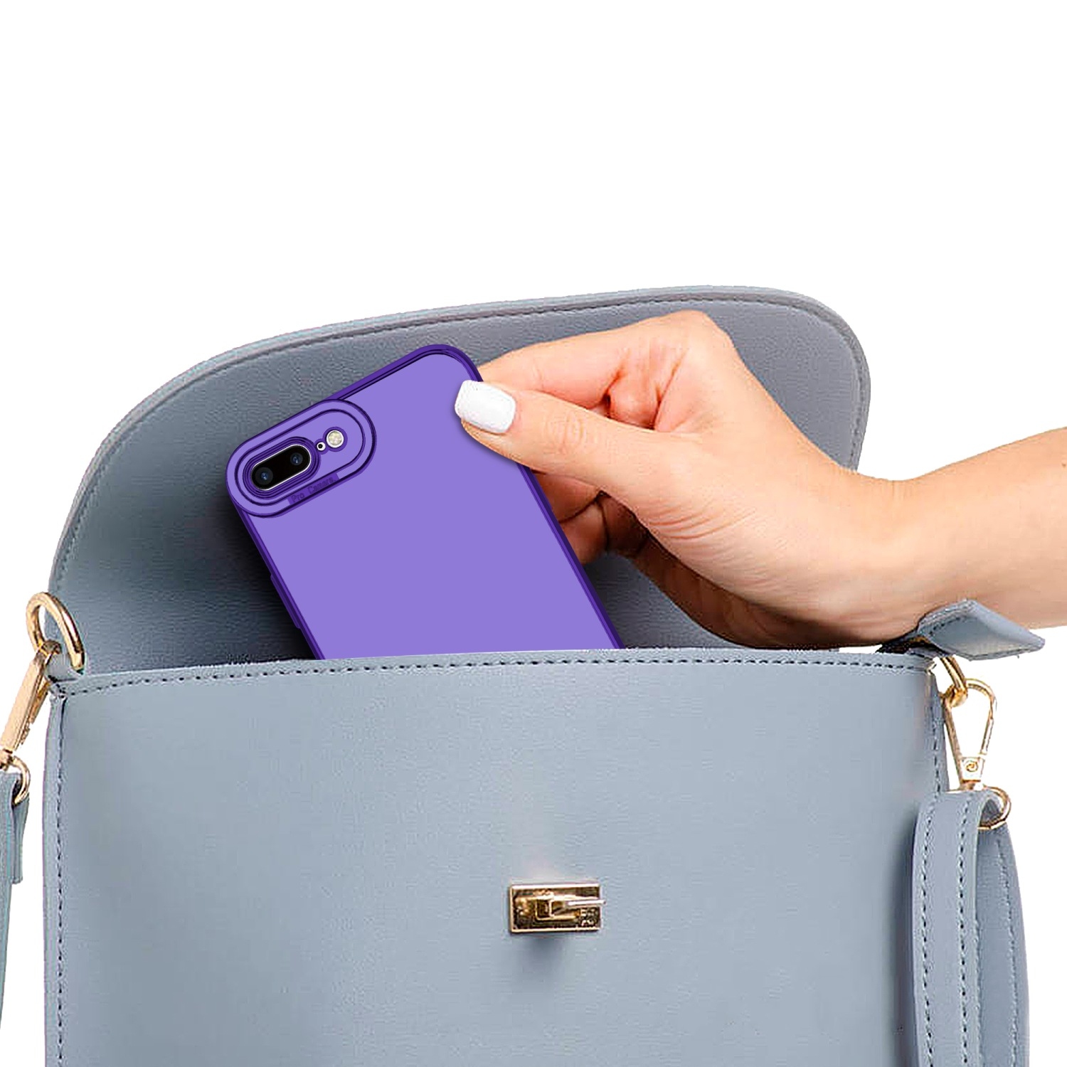 Eine lila Handyhülle wird in einer blauen Handtasche platziert, gehalten von einer Hand mit weißem Nagel.