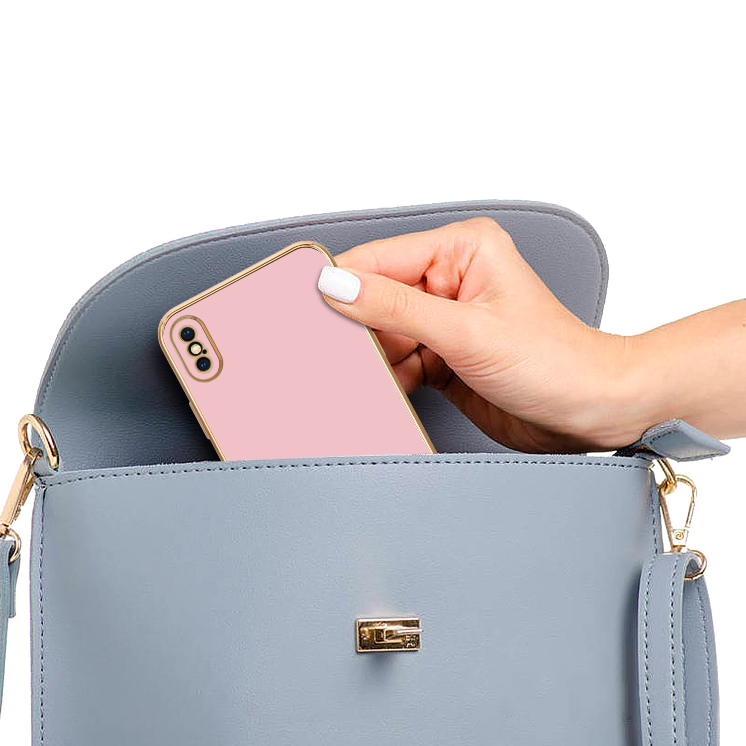 Eine Hand legt ein rosa Telefon mit Hülle in eine blaue Geldbörse mit goldenem Verschluss.