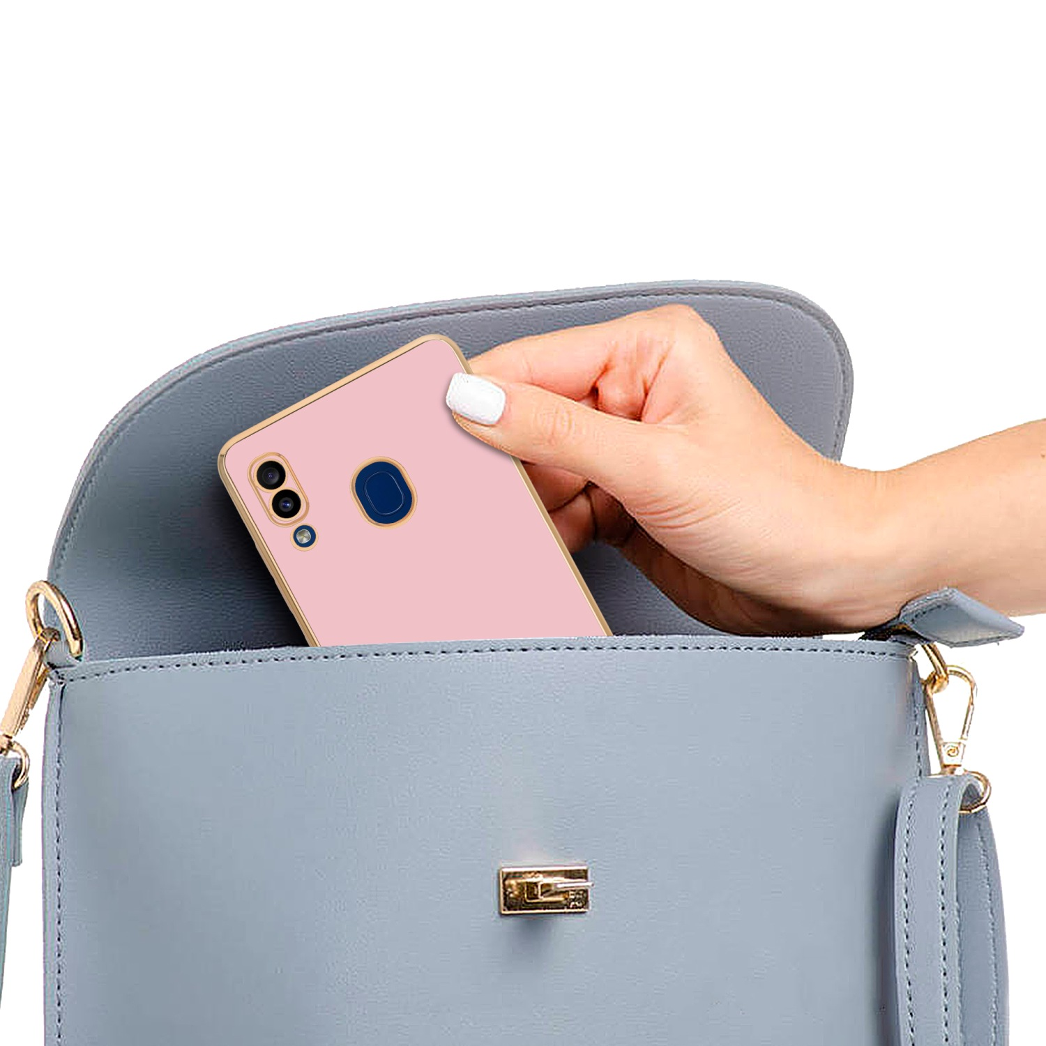 Hand steckt eine rosa Handyhülle in eine hellblaue Handtasche.