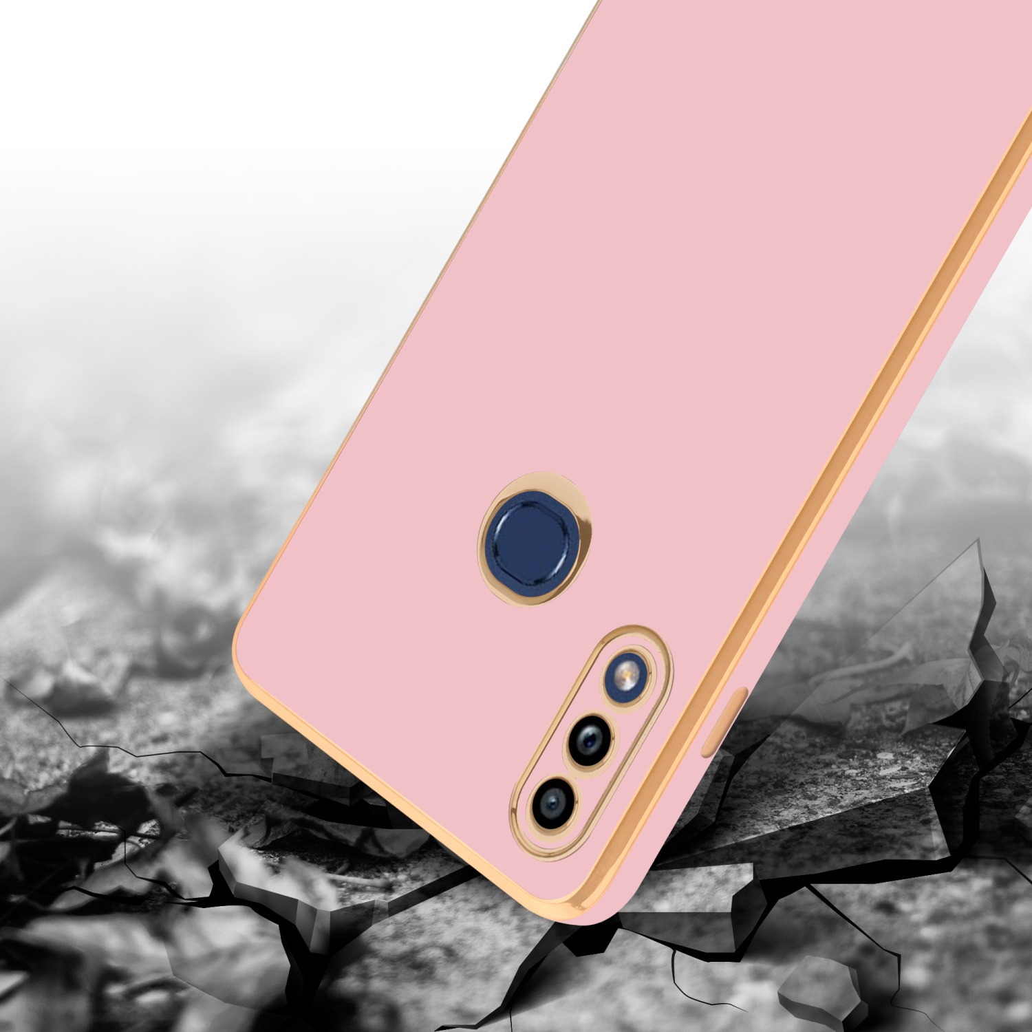Eine pinkfarbene Handyhülle mit goldenem Rand liegt auf einer zerbrochenen Oberfläche. Das Telefon hat drei Kameras.