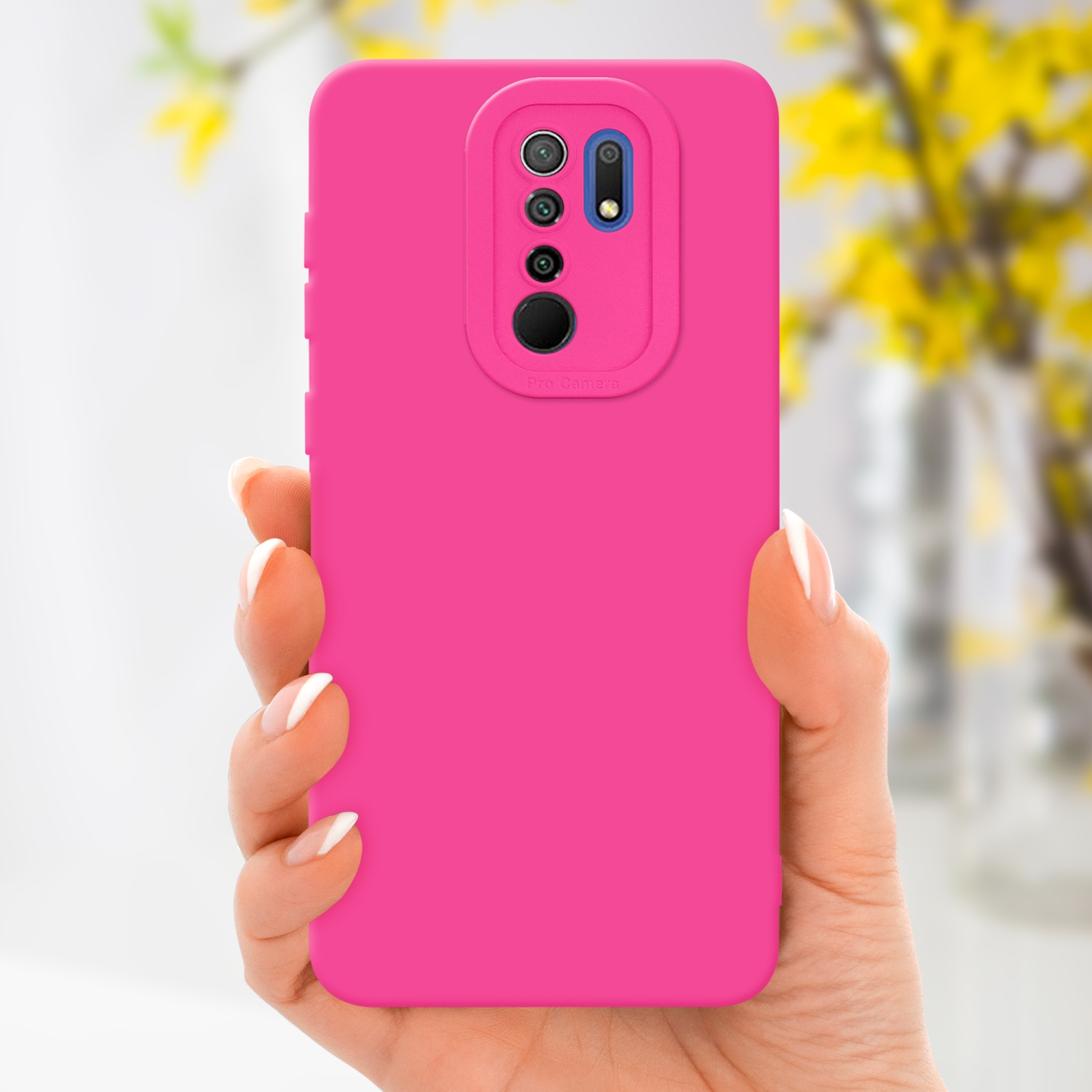 Mano che tiene un telefono rosa con custodia rosa. Fiori gialli sullo sfondo.