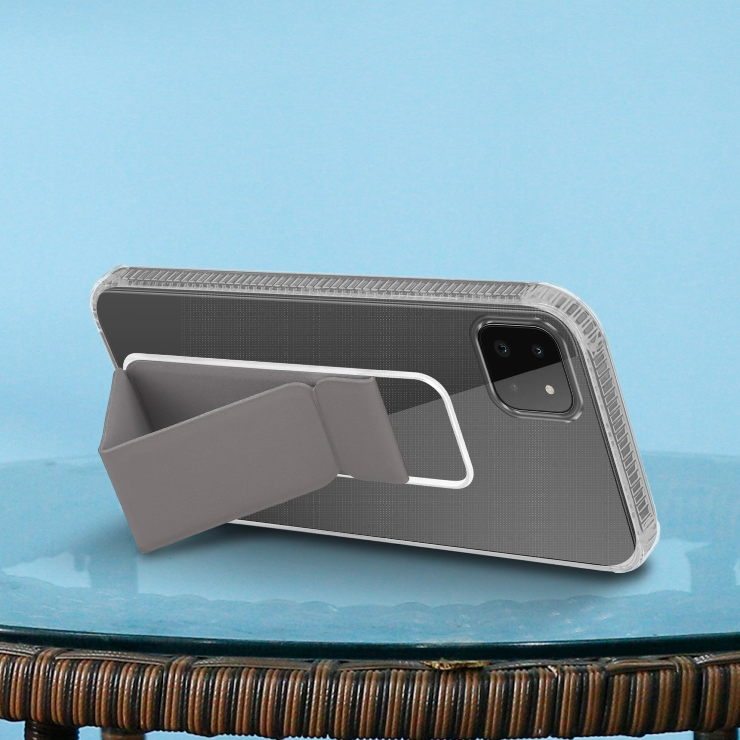 Transparente Handyhülle mit Ständer, auf Tisch, mit blauem Hintergrund, Telefon grau.
