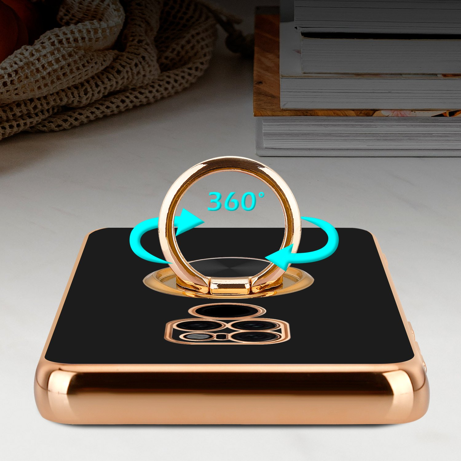 Eine schwarze Handyhülle mit goldenem Ring und Telefon. Ein Tisch ist der Hintergrund.