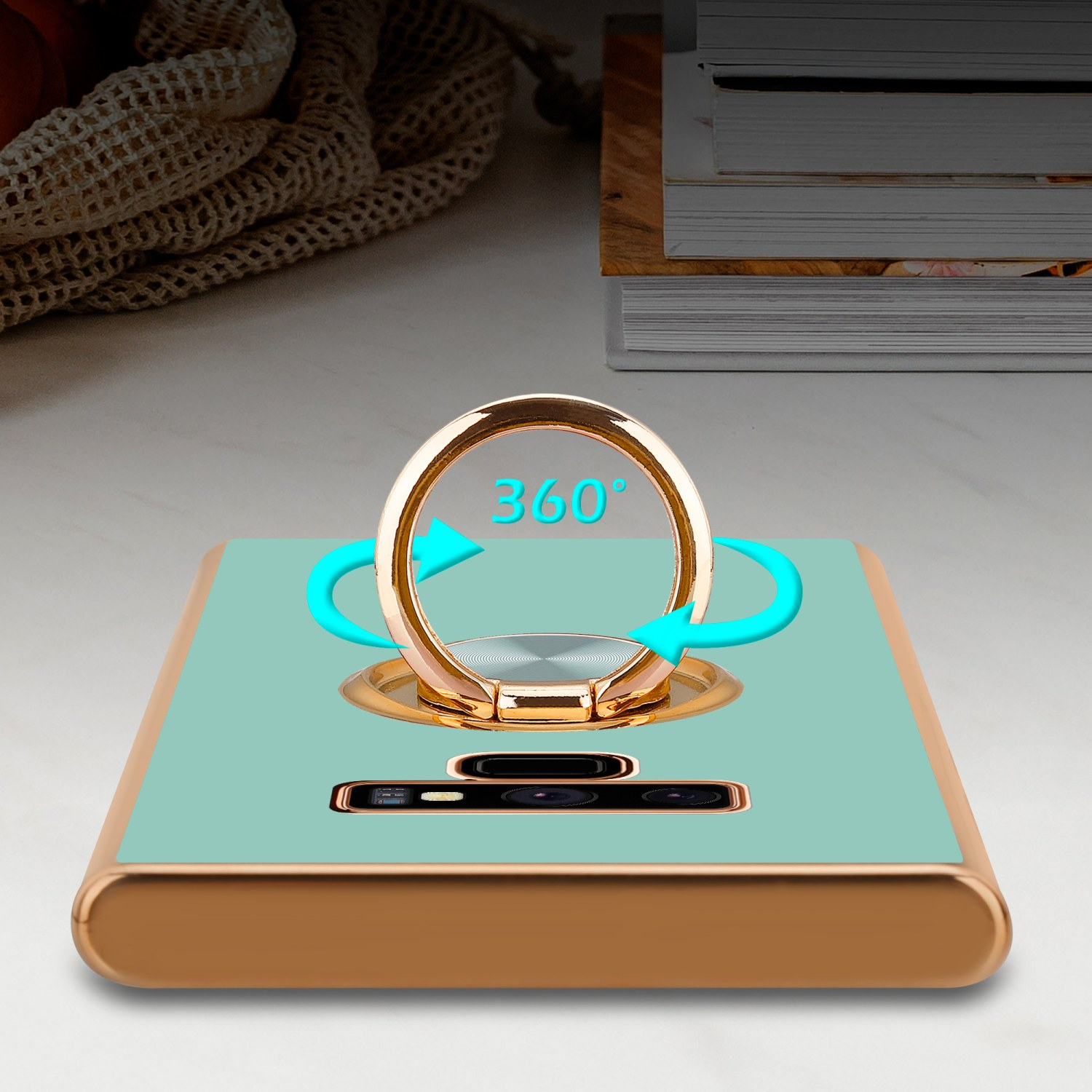 Handyhülle mit goldenem Ring und Pfeilen auf einem weißen Tisch.