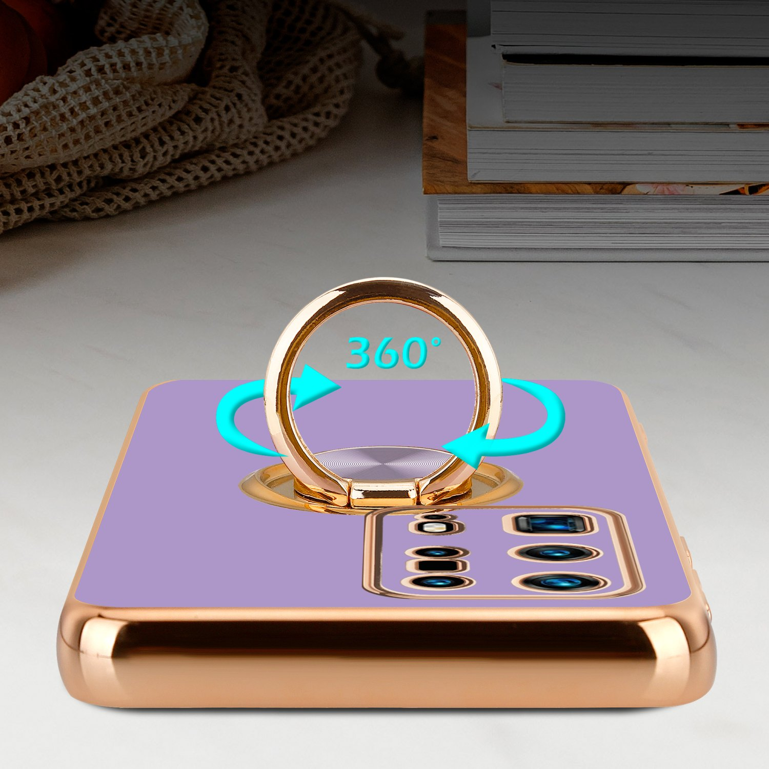 Lila Handyhülle mit goldenem Ring auf weißem Tisch. Türkisfarbene Pfeile um den Ring, das Handy hat eine Kamera.