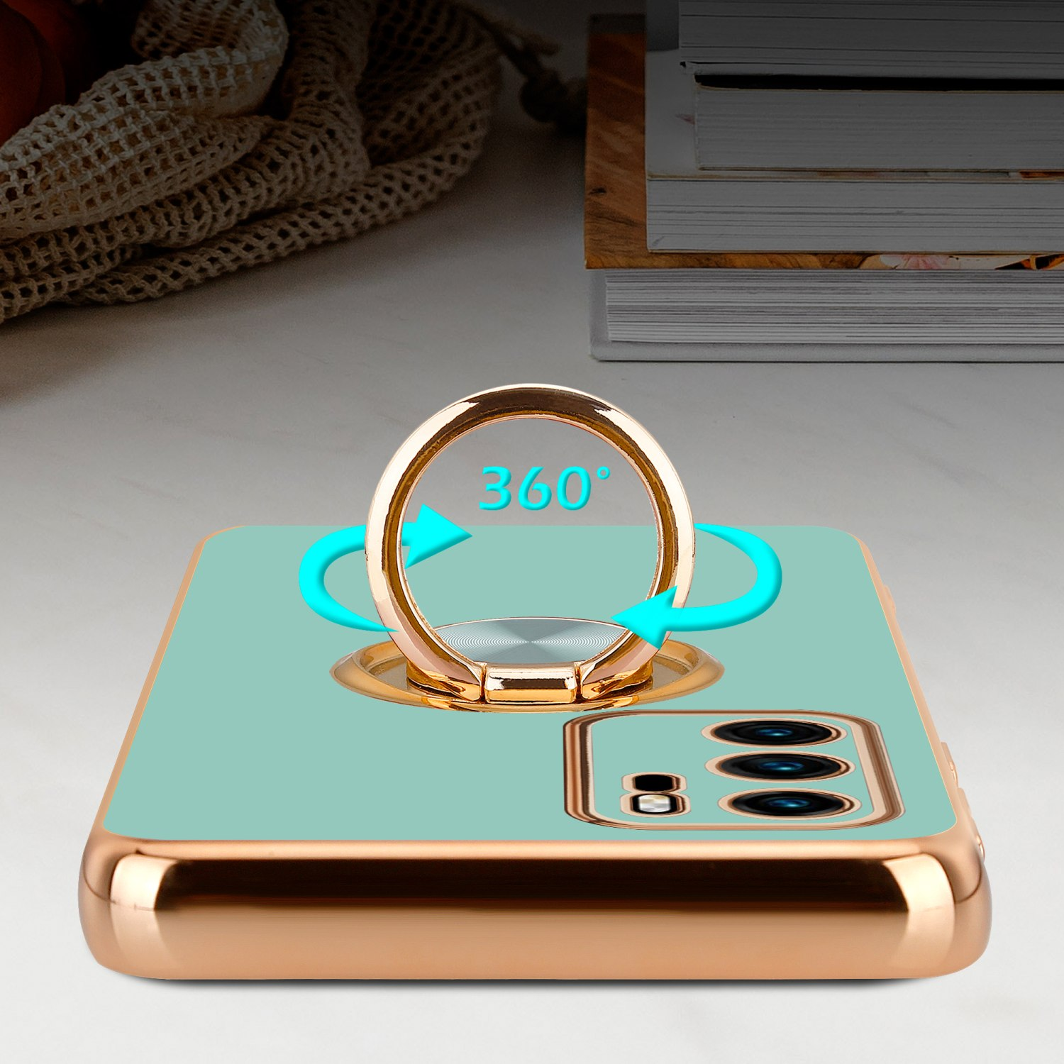 Eine Handyhülle mit goldenem Ring und Pfeilen, der Ring zeigt 360 Grad. Der Hintergrund ist verschwommen.