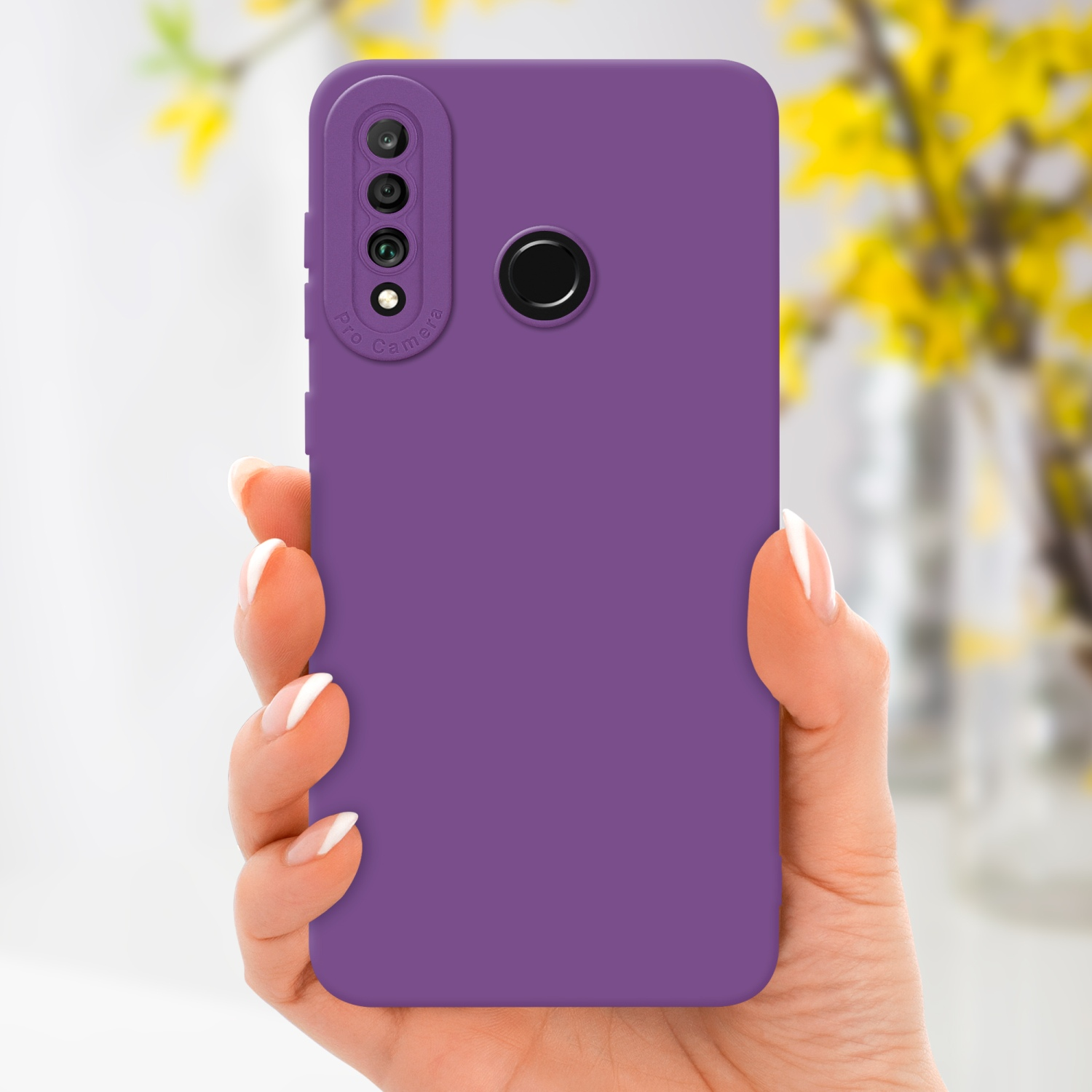Mano che tiene telefono viola con tripla fotocamera e custodia viola, fiori sfocati.