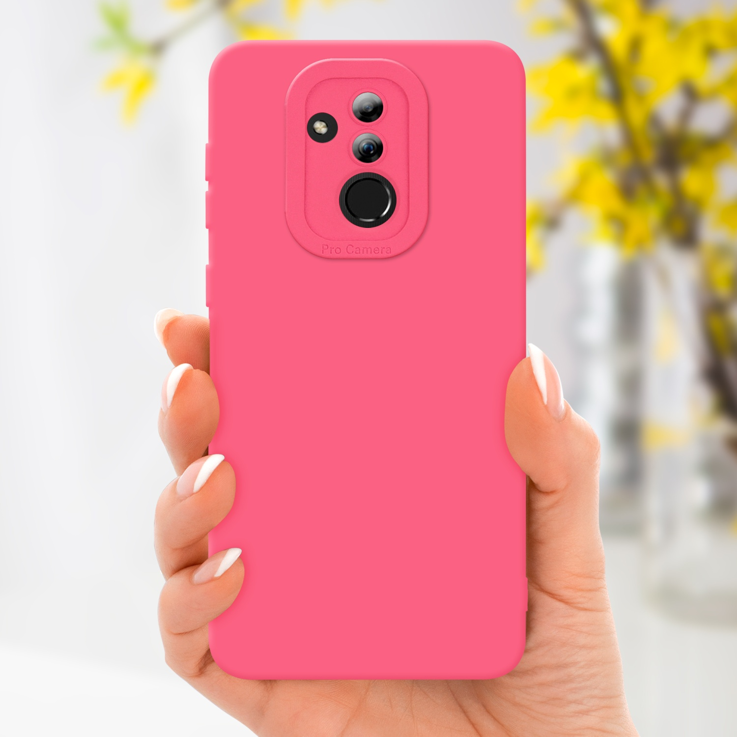 Mano che tiene una custodia rosa per telefono. Fiori gialli sullo sfondo, unghie bianche.