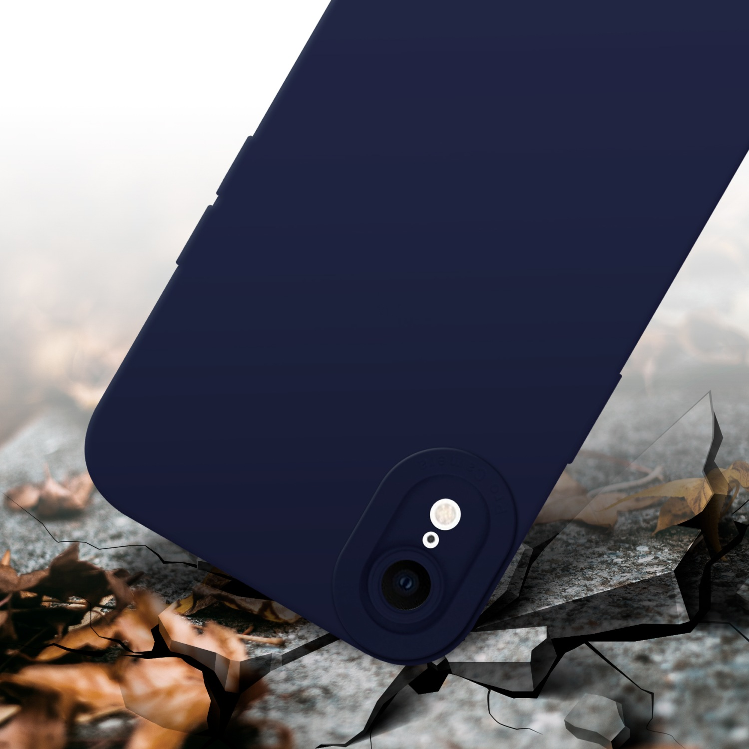 Custodia del telefono blu navy su una superficie incrinata, con foglie sullo sfondo.