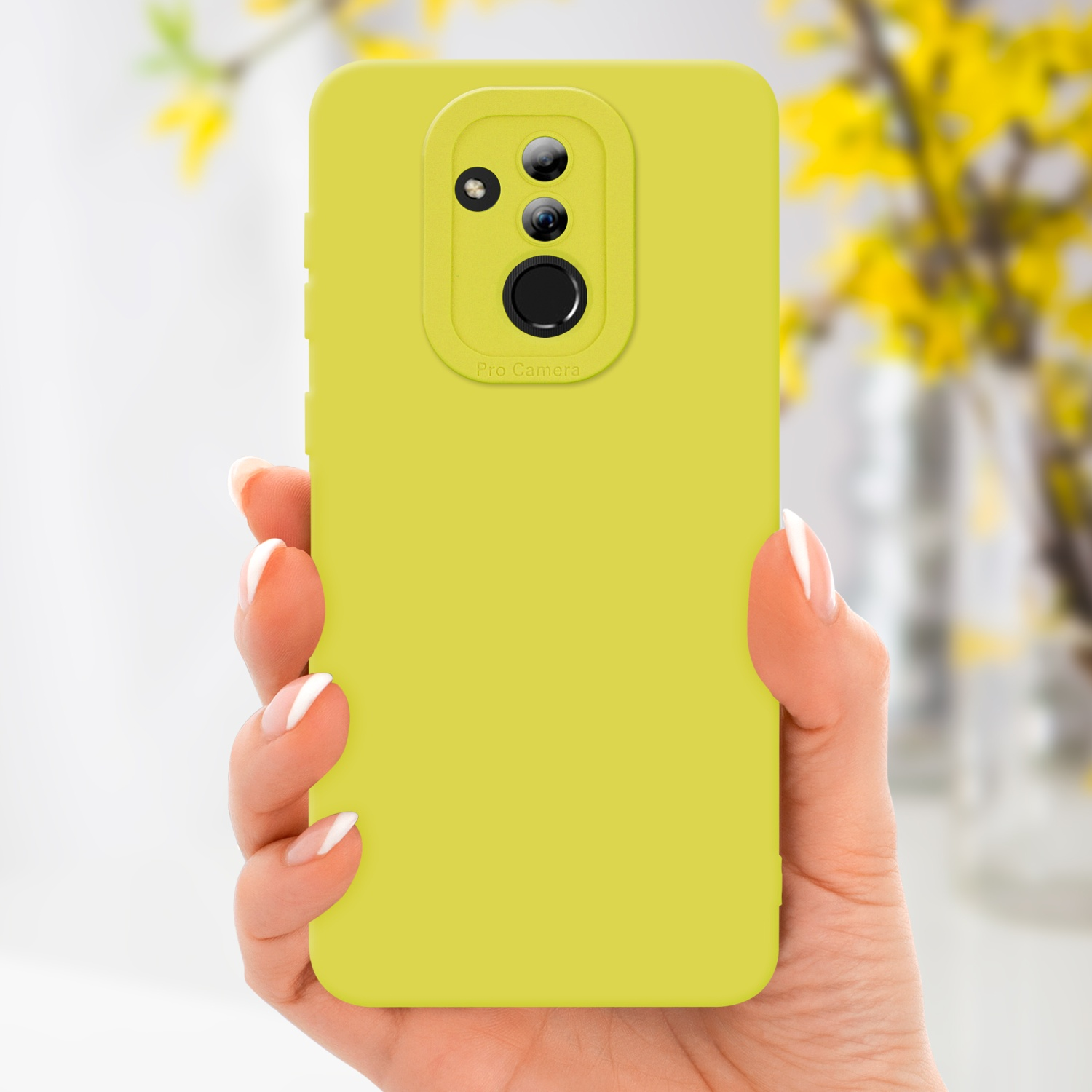 Una mano che tiene una custodia gialla per telefono. Fiori gialli sfocati sullo sfondo.