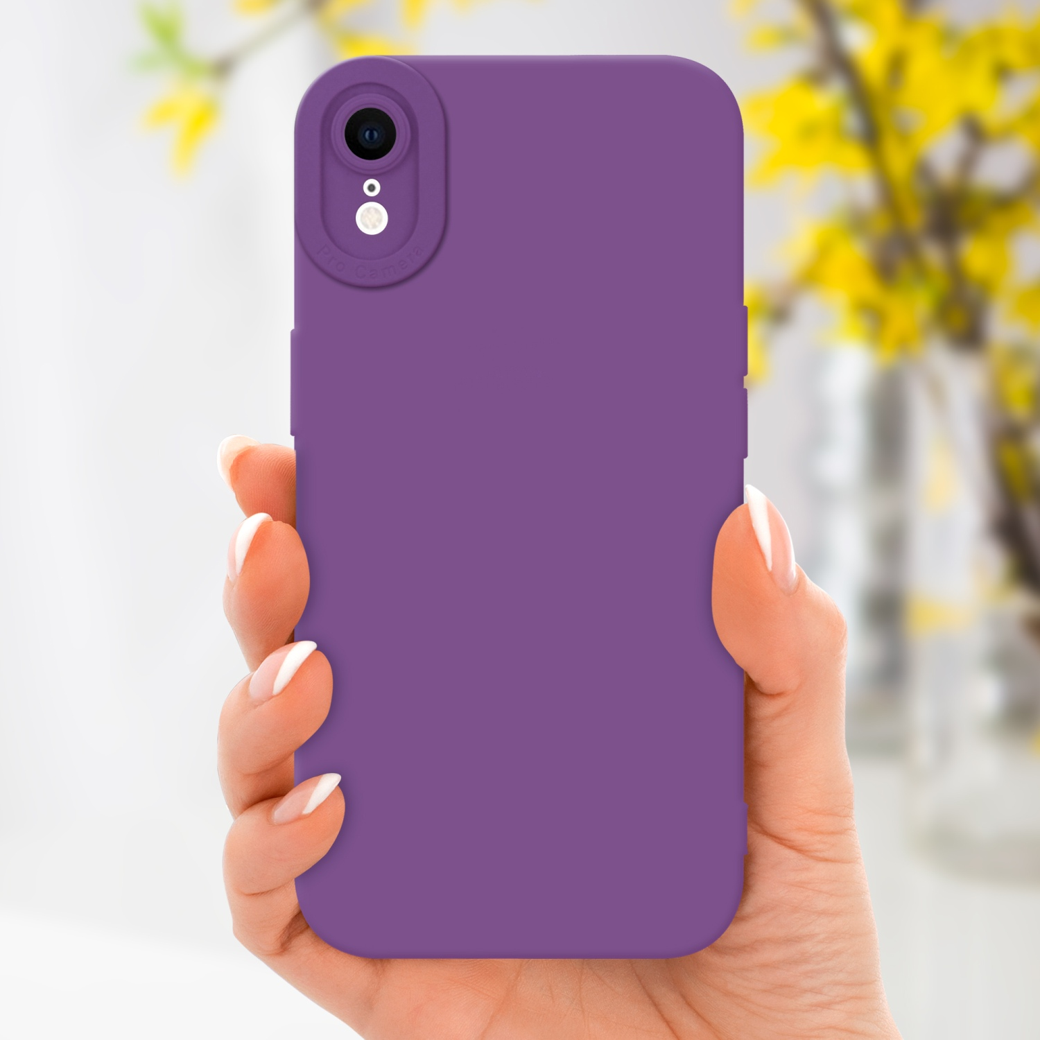 Mano che tiene una custodia viola per telefono. Fiori gialli sfocati sullo sfondo.