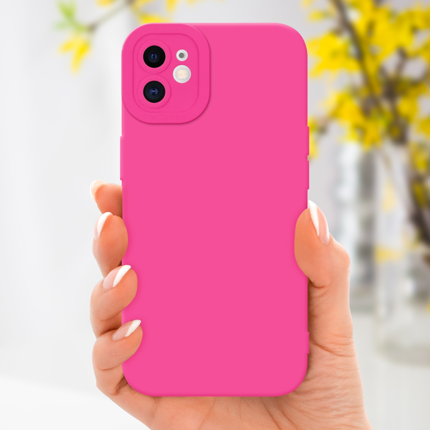 Una mano tiene una custodia per telefono rosa. Fiori gialli sullo sfondo, sfondo bianco.