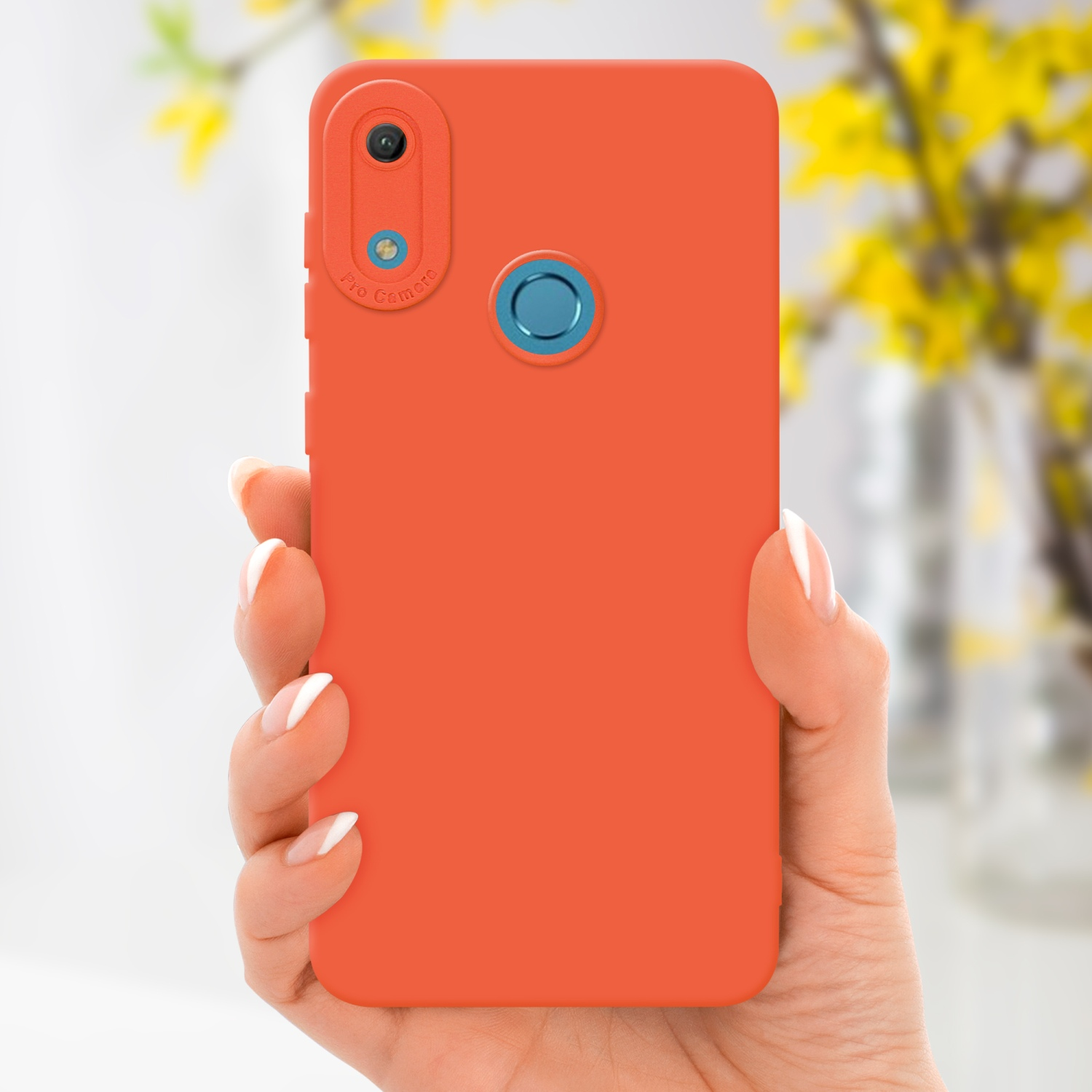 Main tenant un téléphone orange. Des fleurs jaunes sont visibles en arrière-plan.
