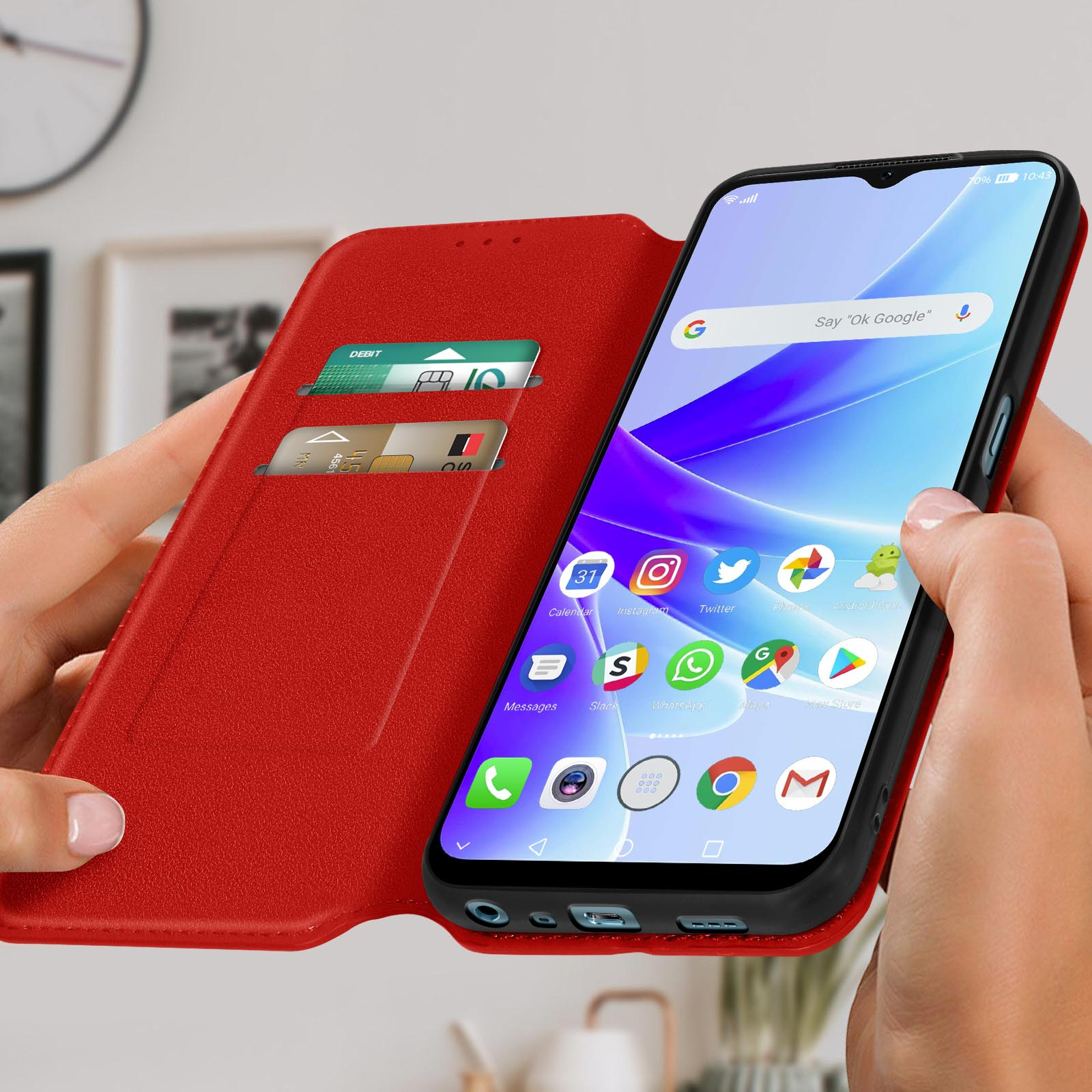 Una persona che tiene un telefono in una custodia a portafoglio rossa, che mostra uno schermo con app e carte.
