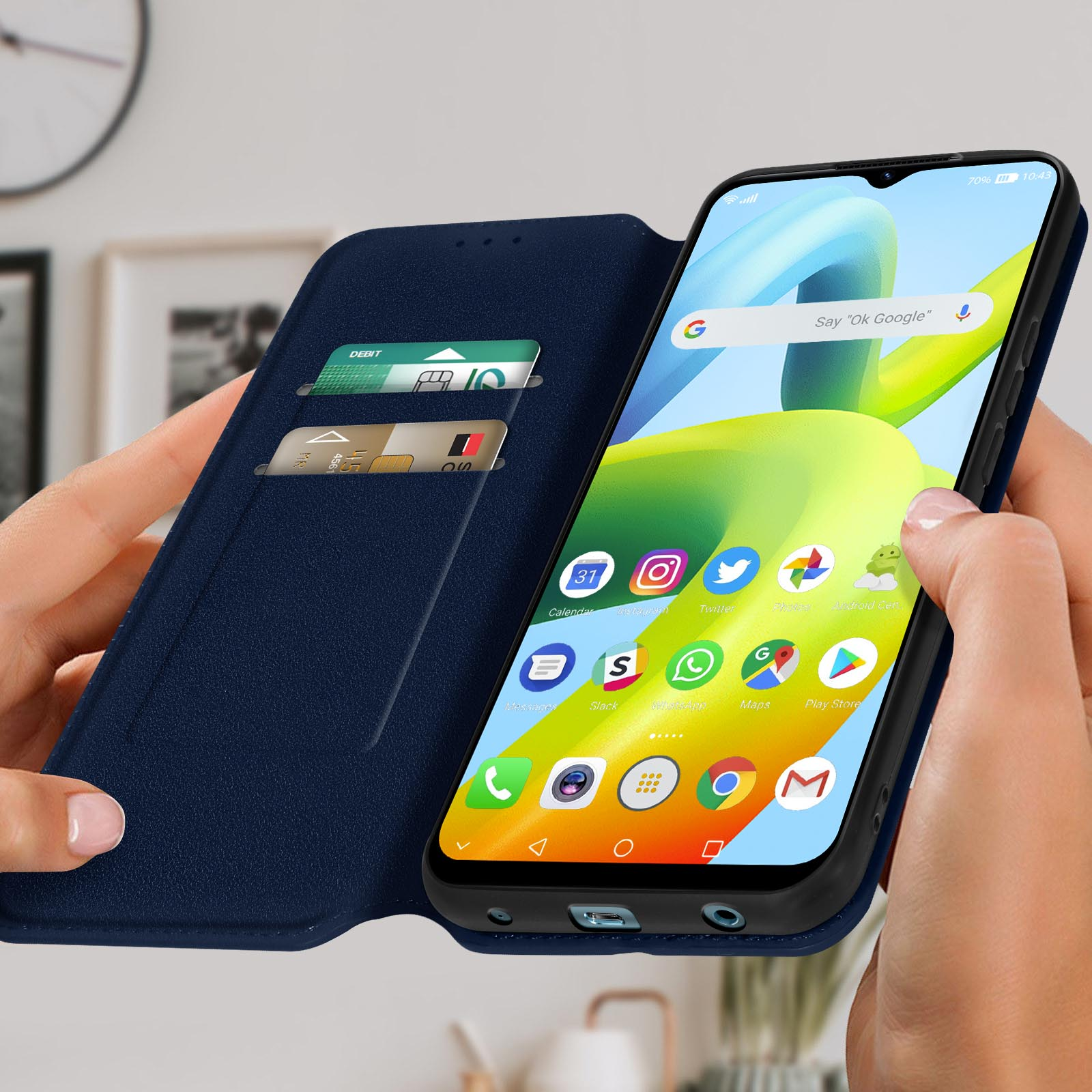 Custodia blu per telefono con telefono dentro, carte e mano che tiene la custodia.