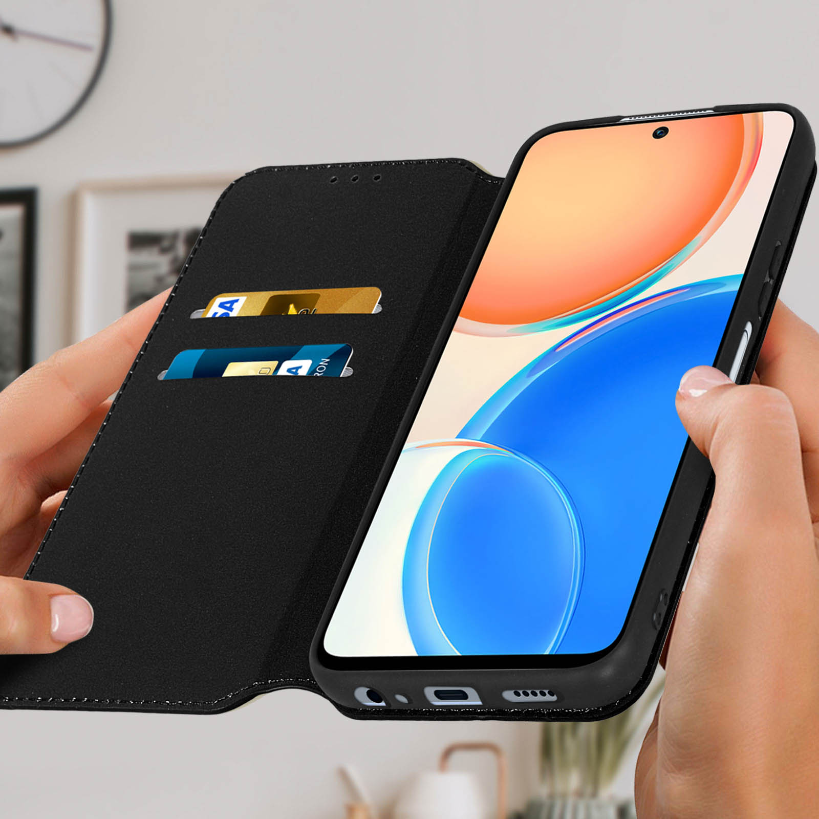 Un étui de téléphone noir avec des cartes, tenu par des mains. Le téléphone est ouvert, montrant un écran coloré.